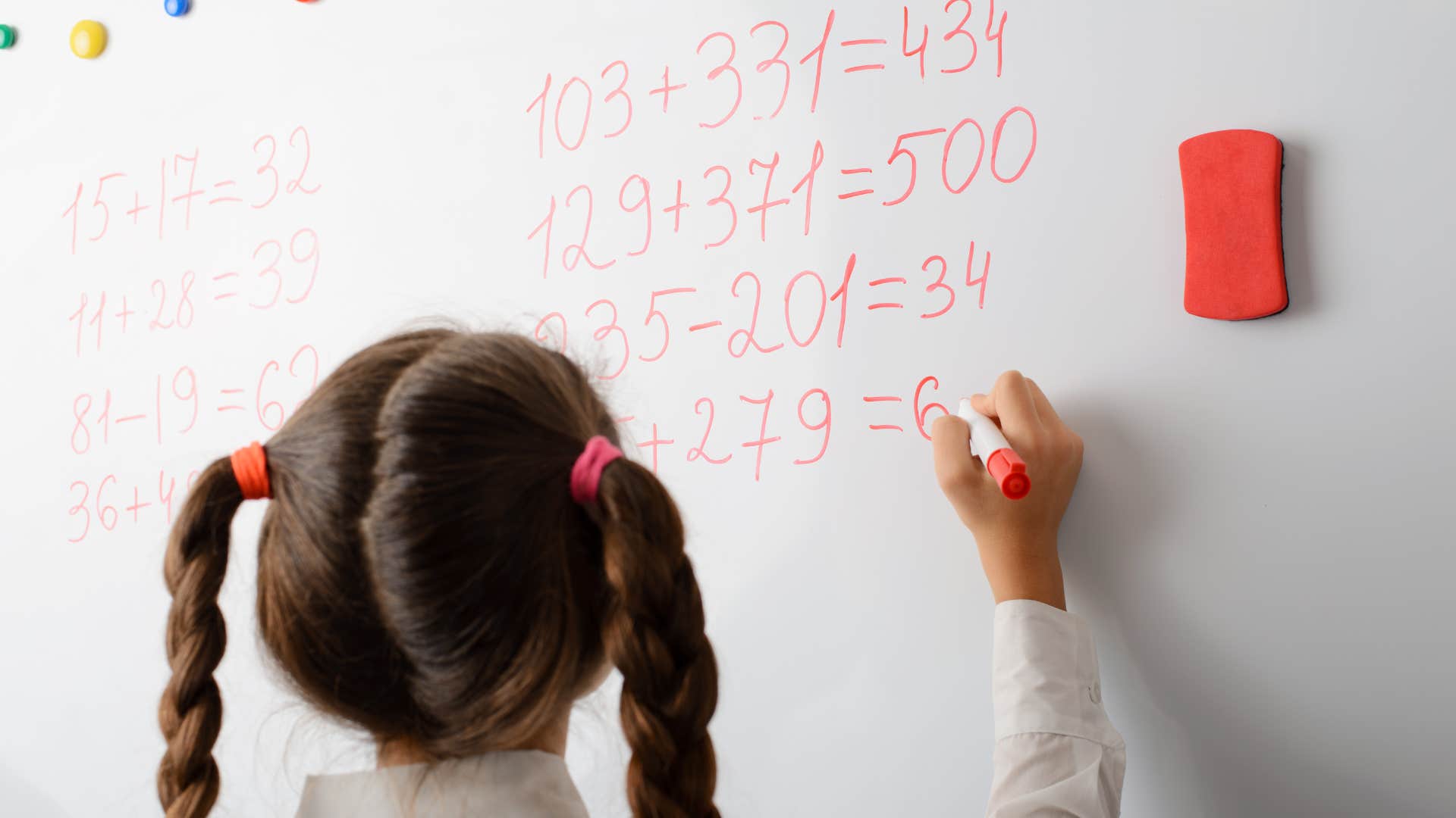 young girl solving math problem in class