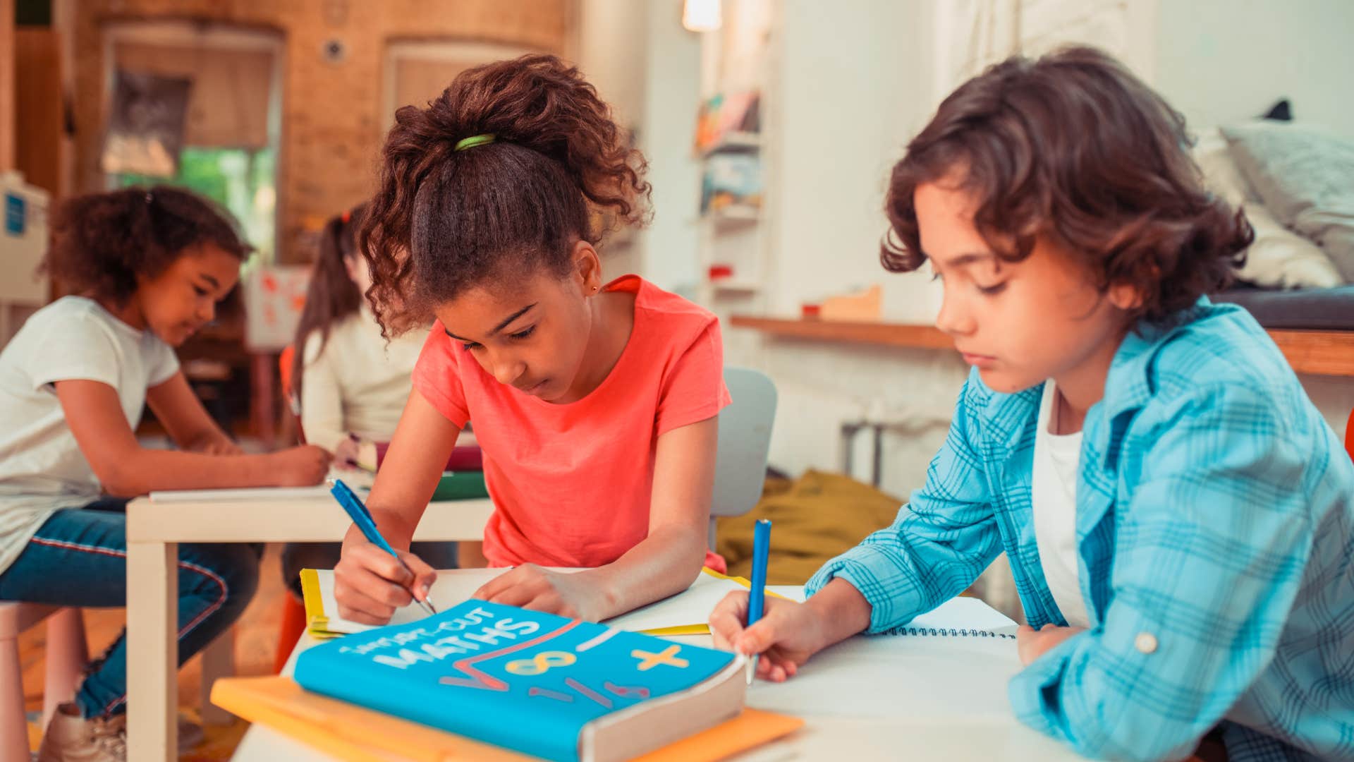 two young students in school writing