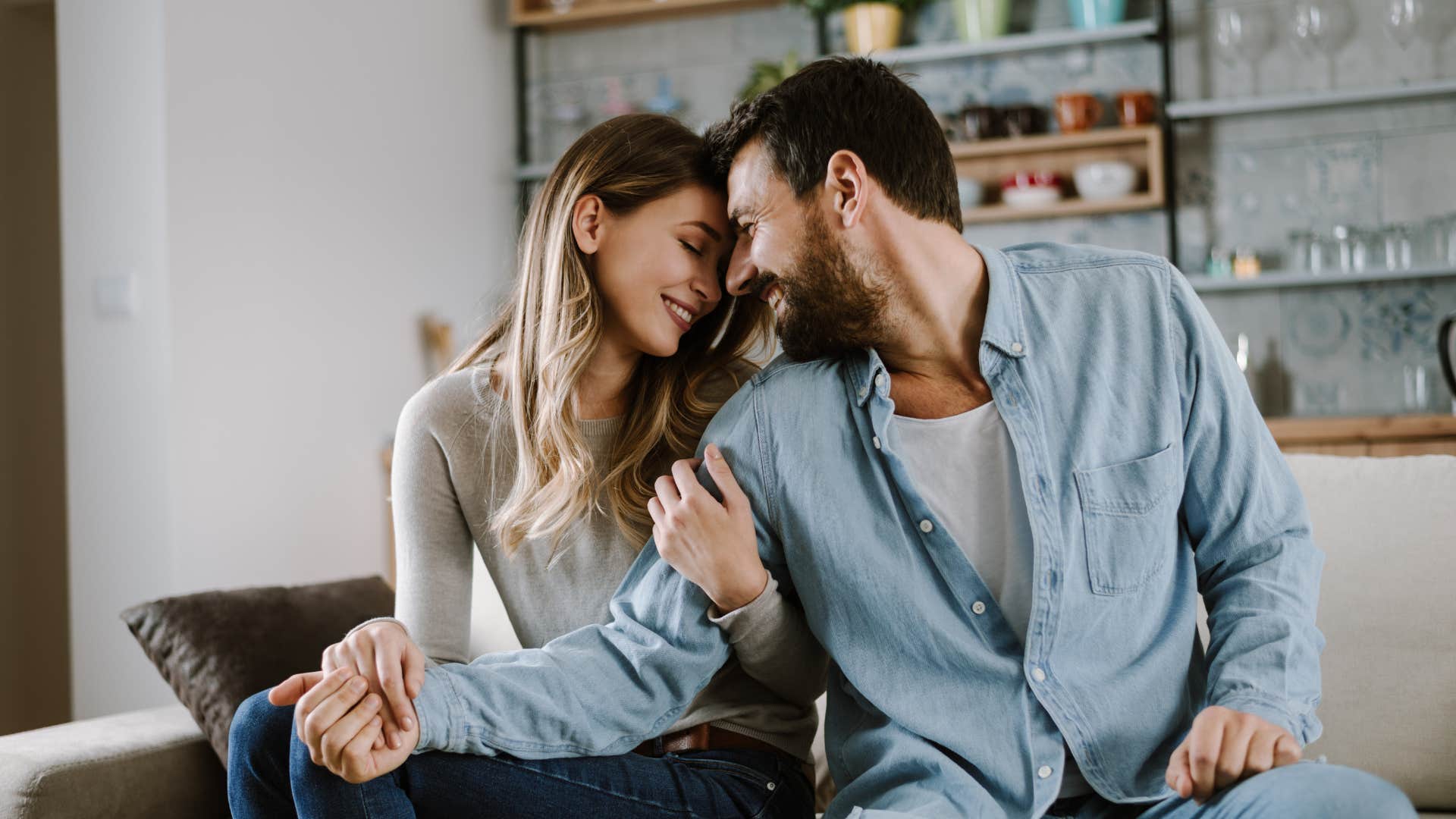 couple getting close on the couch thinking about their relationship