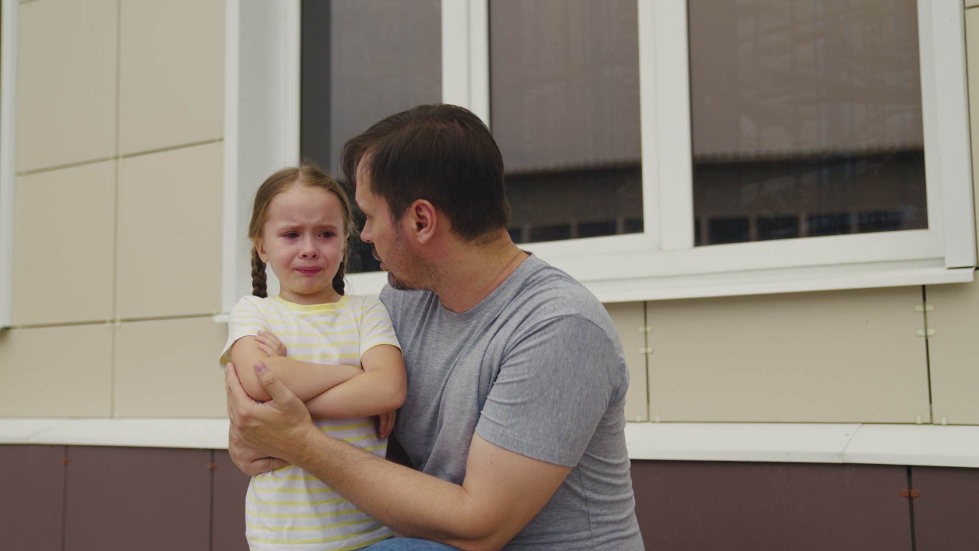 dad shielding his daughter from experiencing discomfort