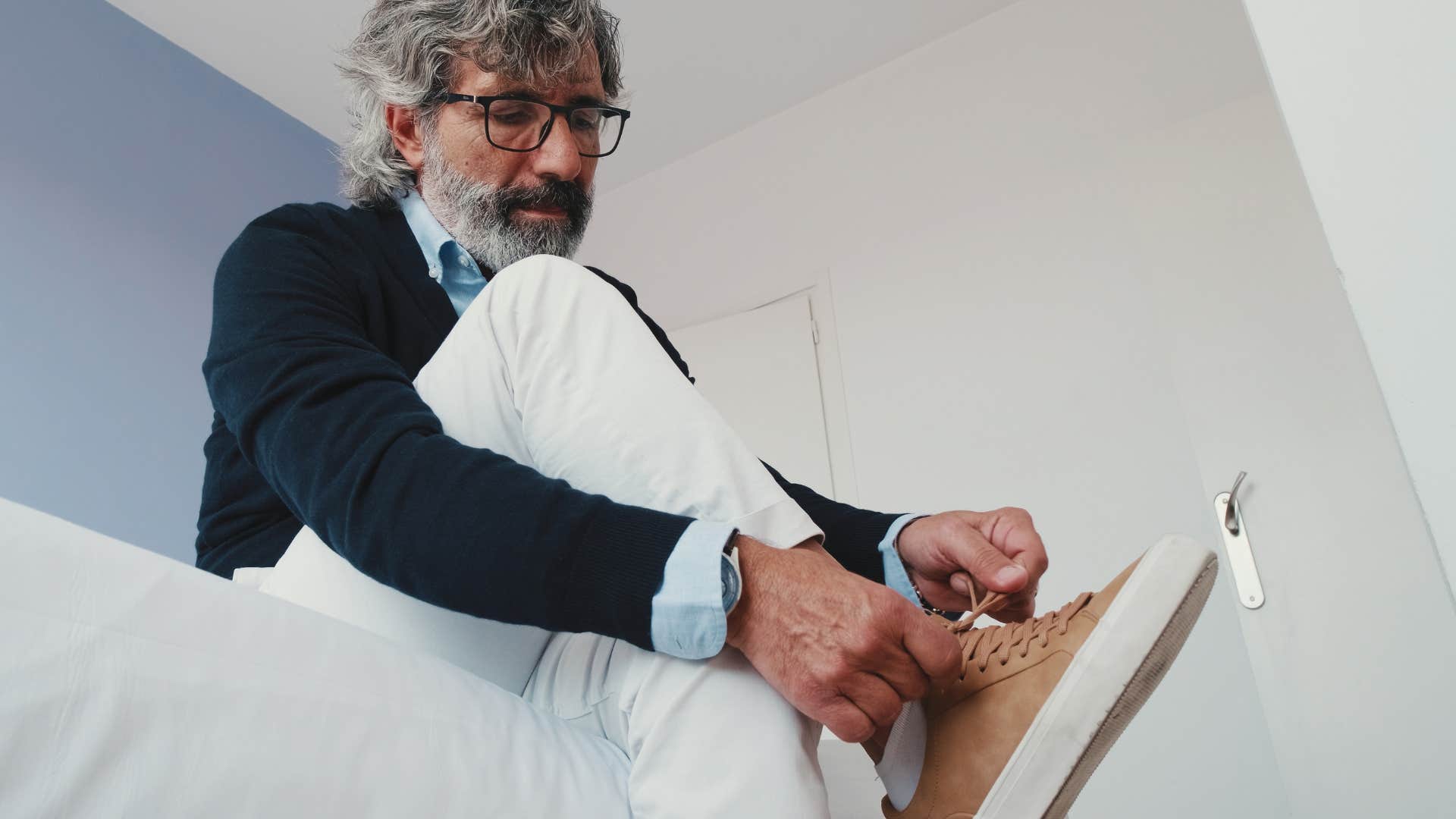 man tying his sneakers that dont fit