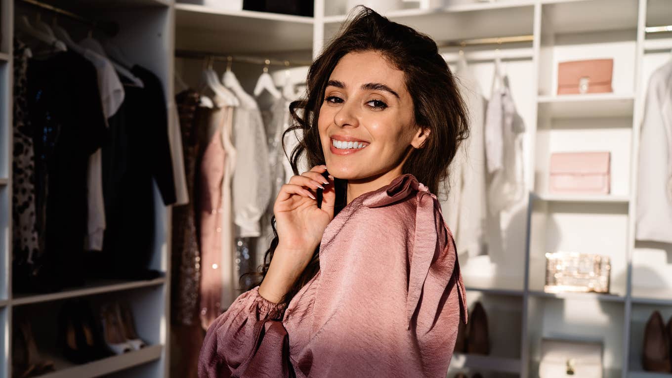 People Can Tell You're Bad With Money If You Have These Things In Your Closet woman who is bad with money standing in her large closet