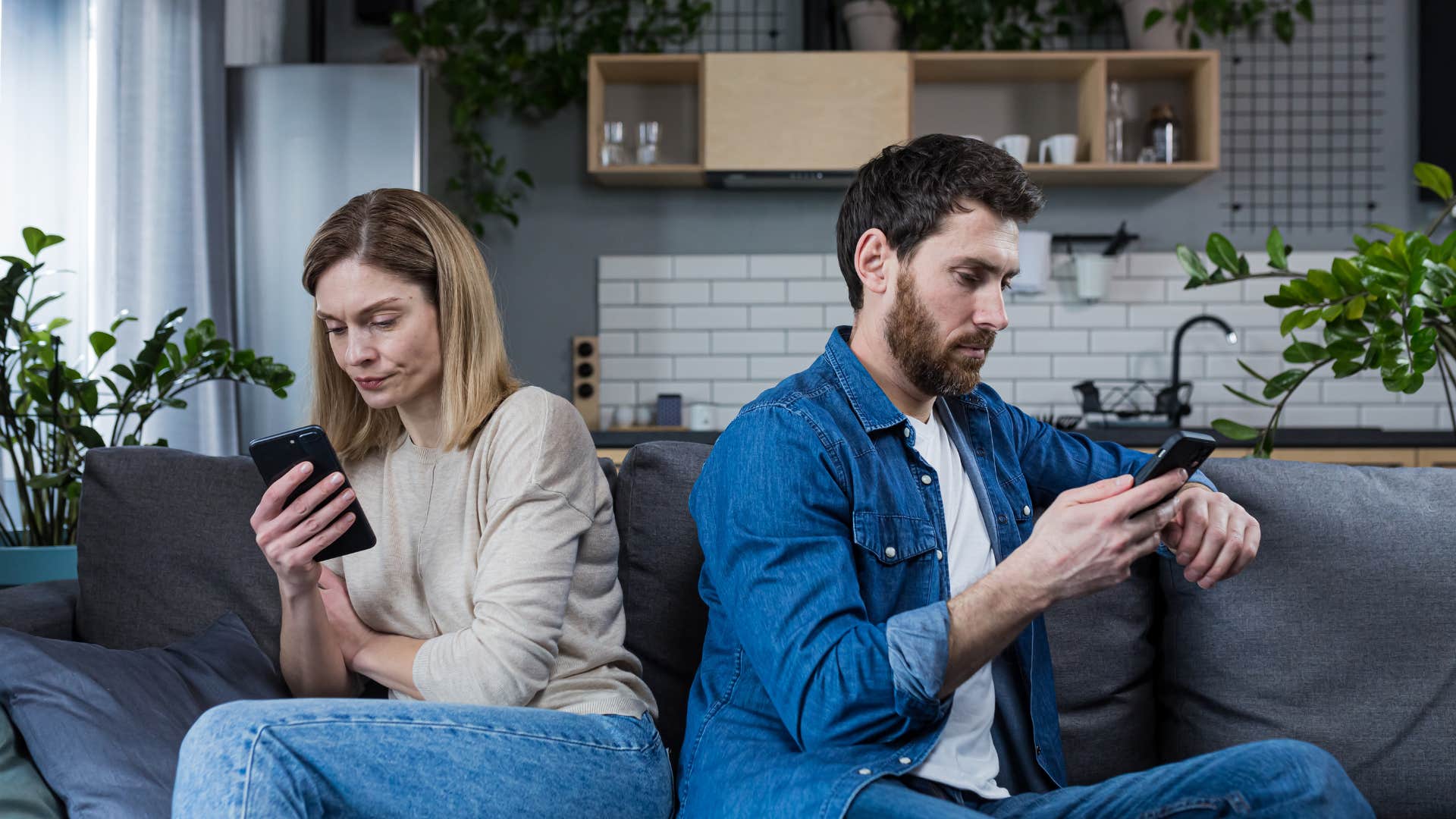 couple sitting next to each other in a super-unhealthy relationship as they email each other