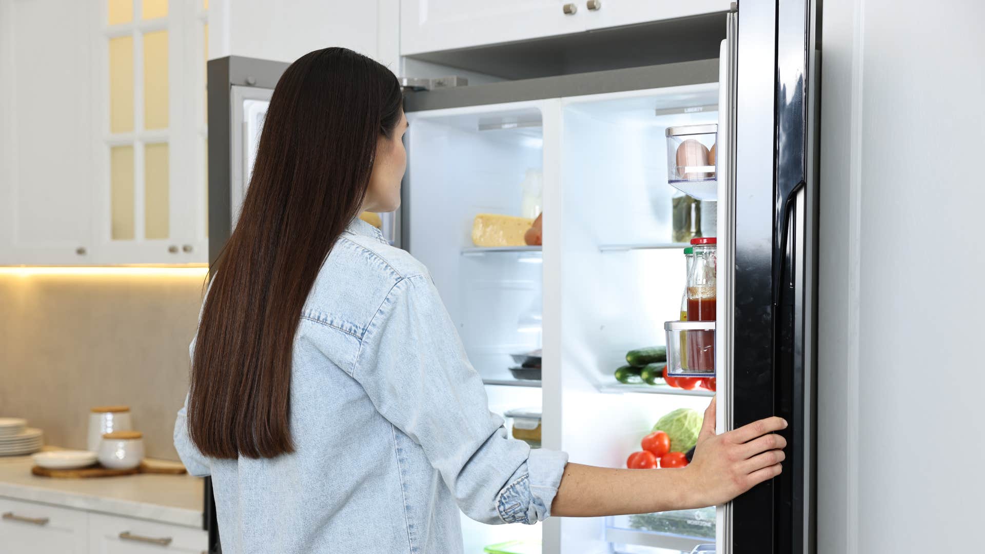 woman opening up the fridge seeing expired food