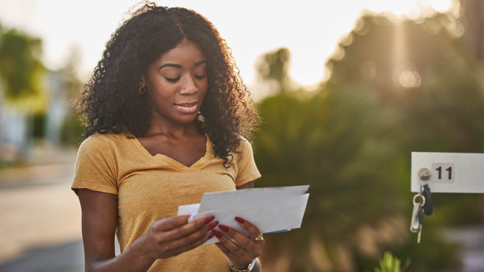 woman finally opening mail at mailbox