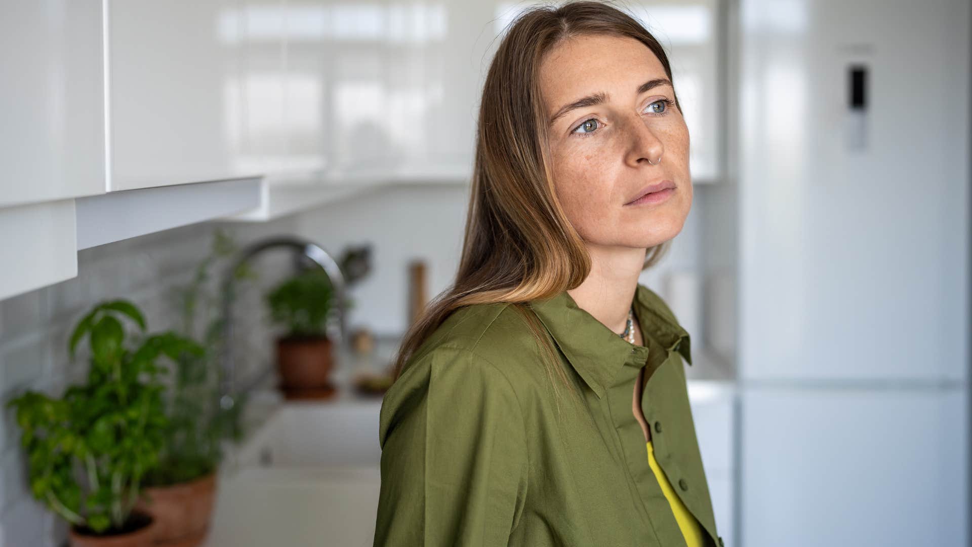 woman thinking shes fine standing in kitchen