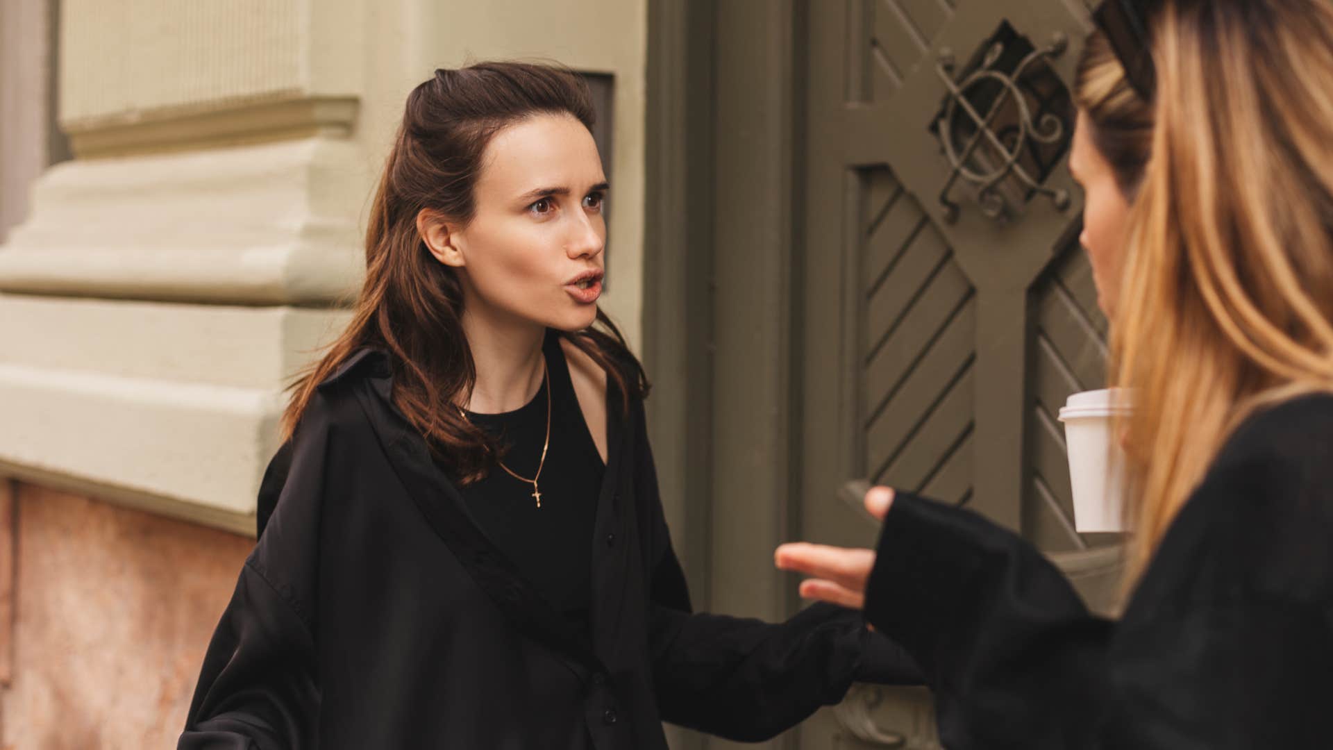 woman in black saying that's not fair to friend as they argue