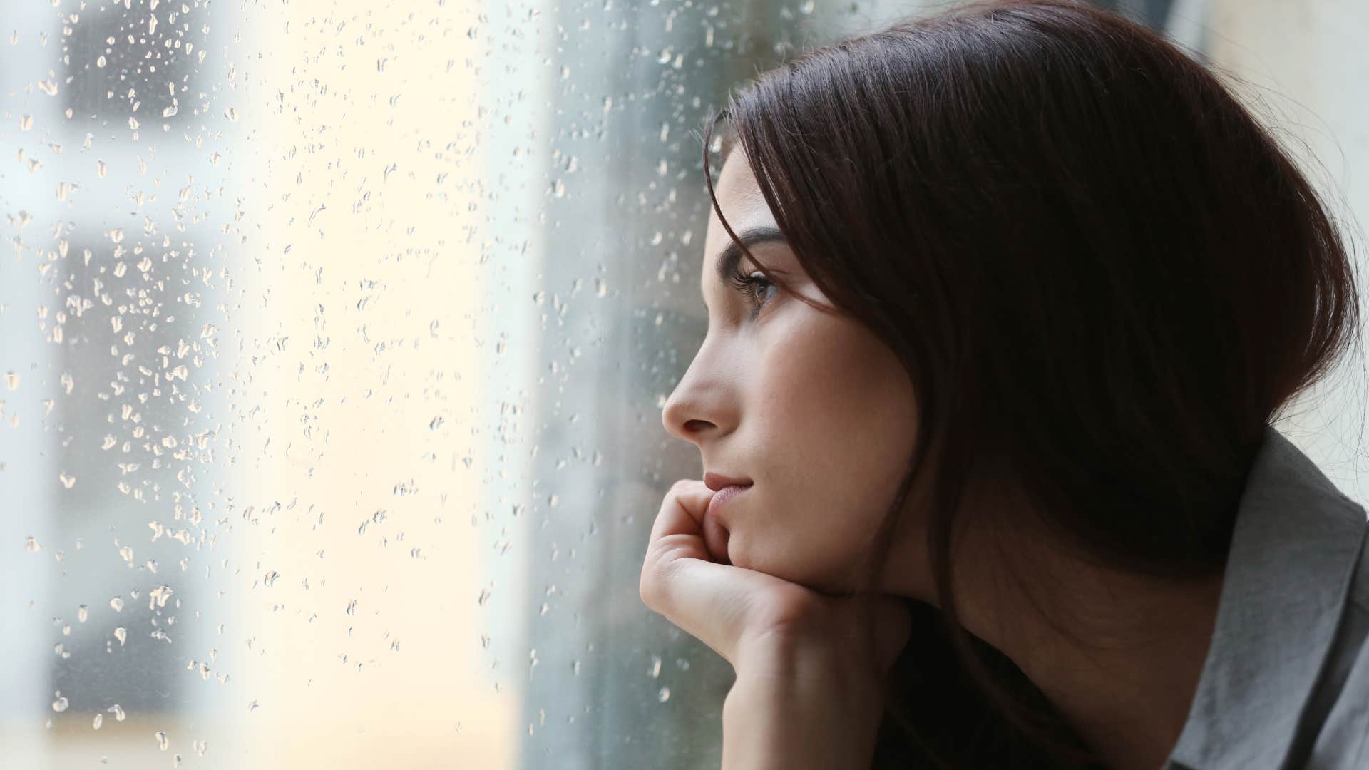 selfish woman looking out of window thinking everyone is against her
