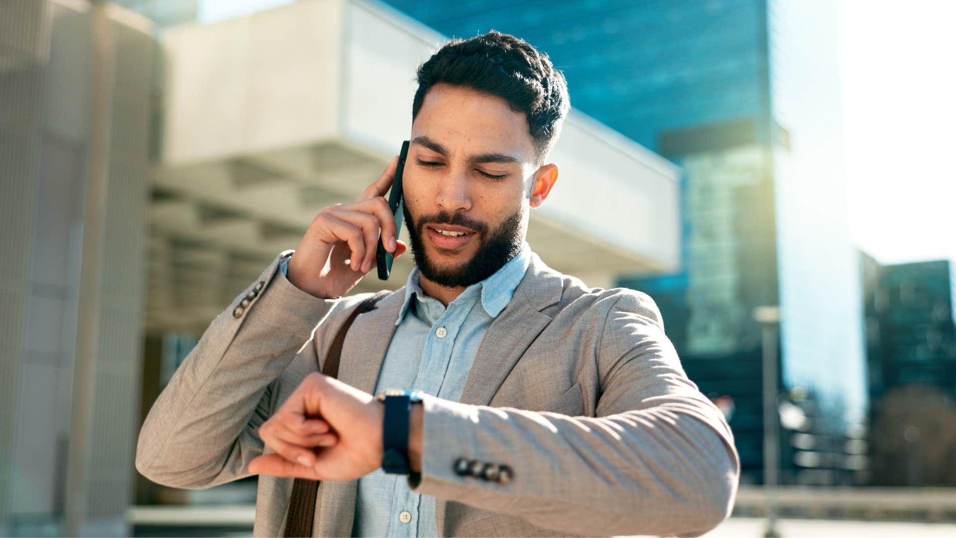 man checking watch telling person on the phone i'm too busy for you