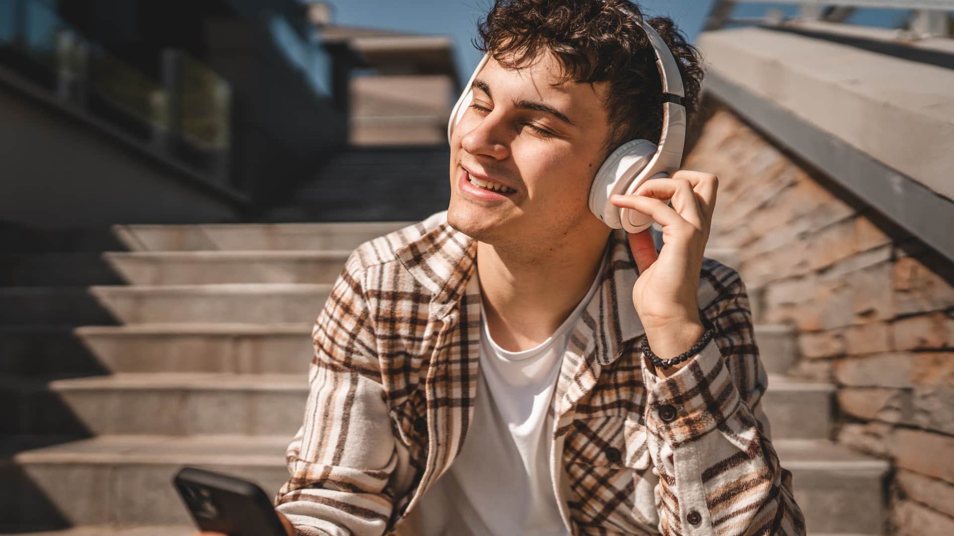 man with intellectual curiosity listening to music outside