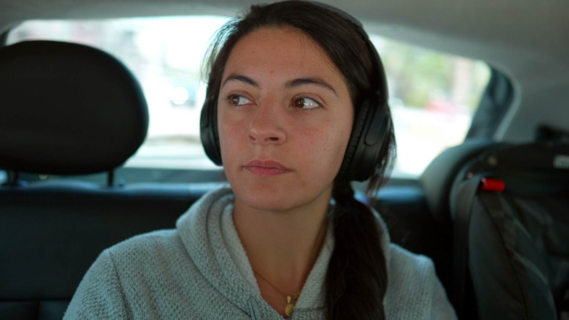 resilient young woman with headphones on in the car
