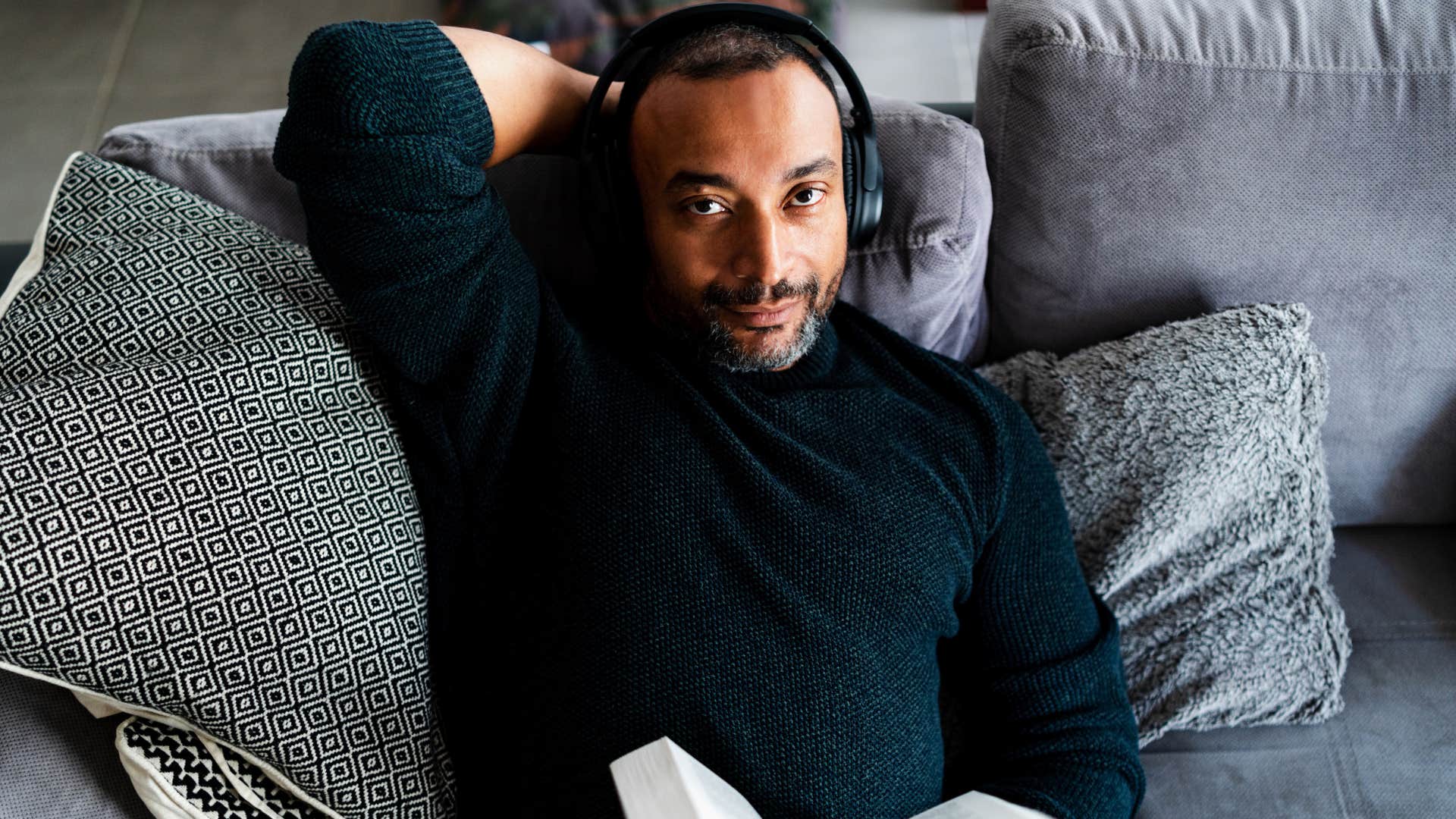 man with heightened sensitivity reading on the couch