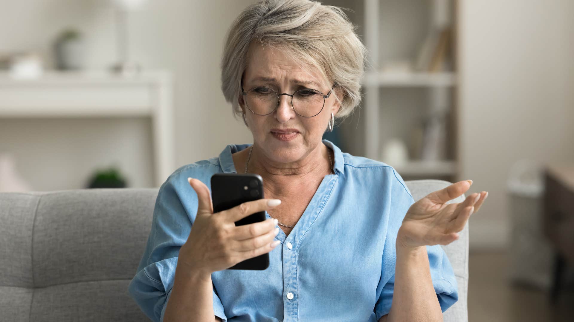 older woman looking at phone frustrated by constant influx of news
