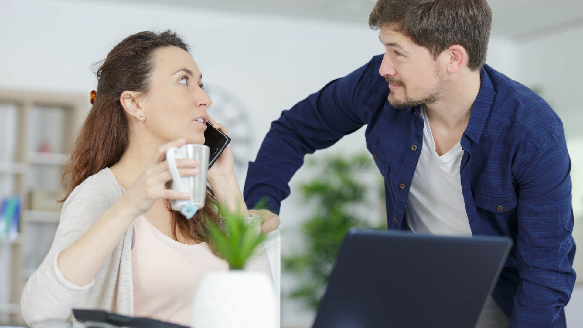 man who lacks compassion as he interrupts woman's conversation on the phone