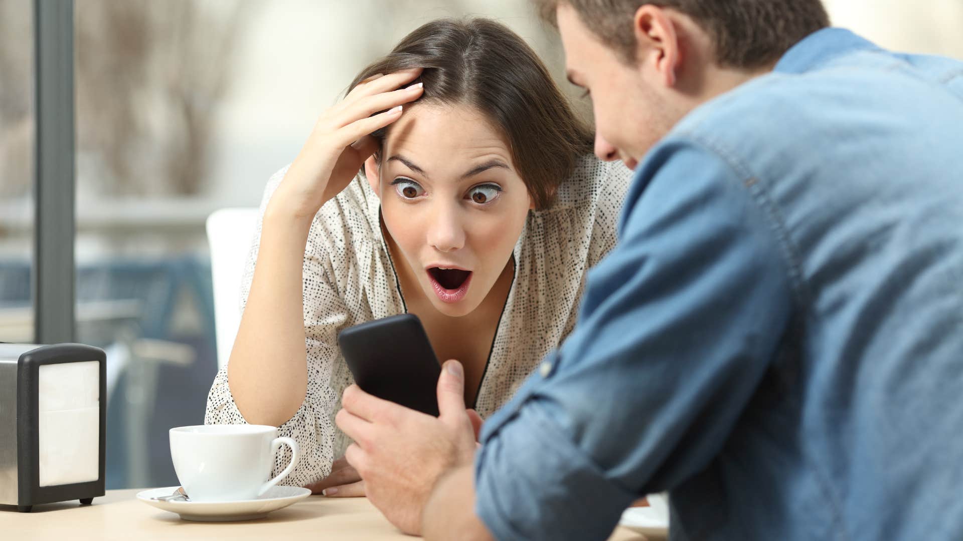woman believing conspiracy theories on her friend's phone