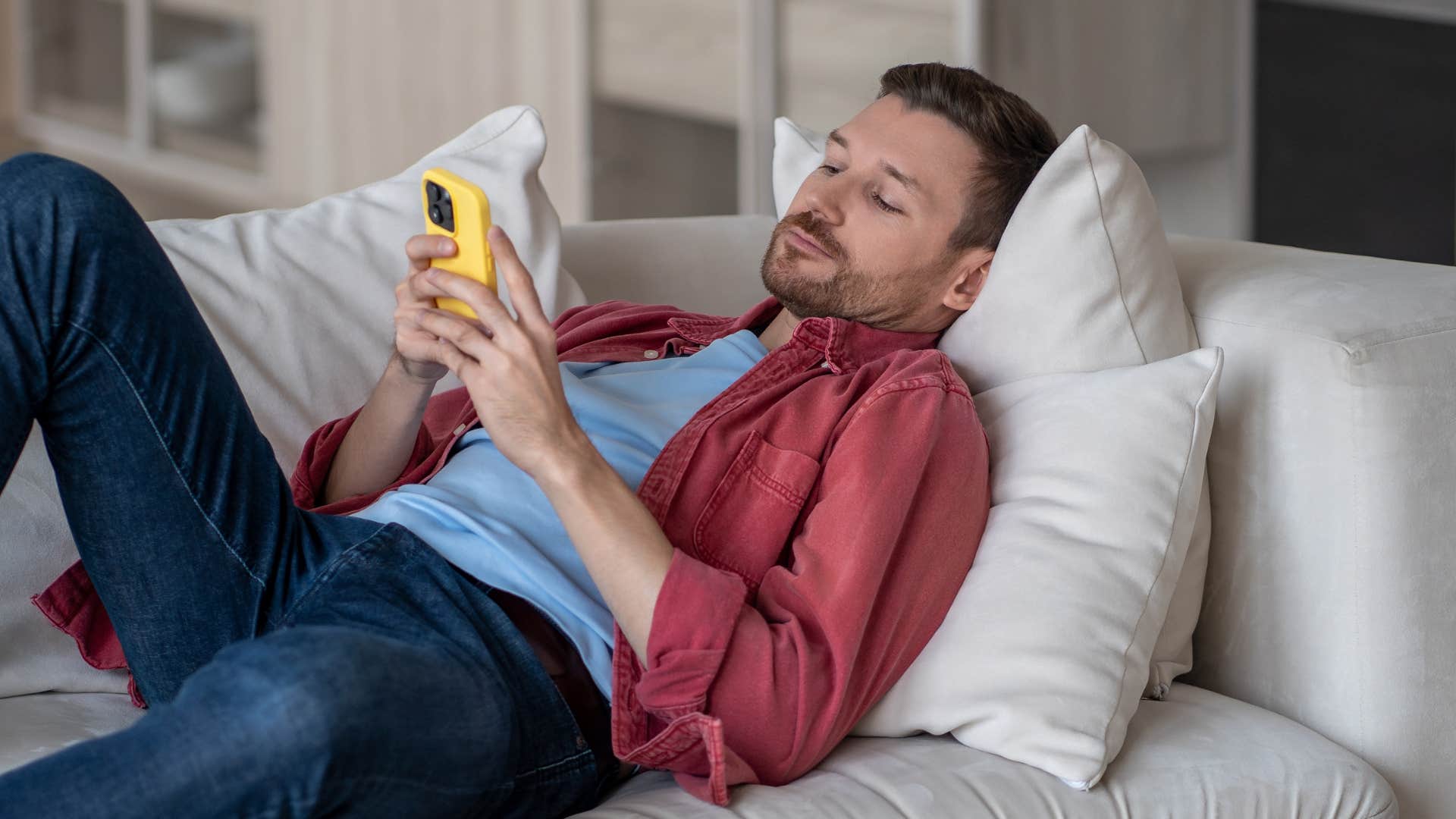 man who lacks street smarts procrastinating while laying on his couch