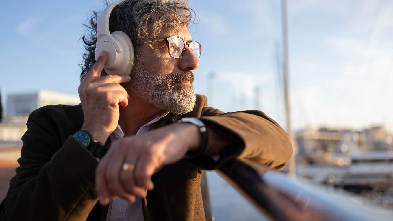 older man listening to music with headphones