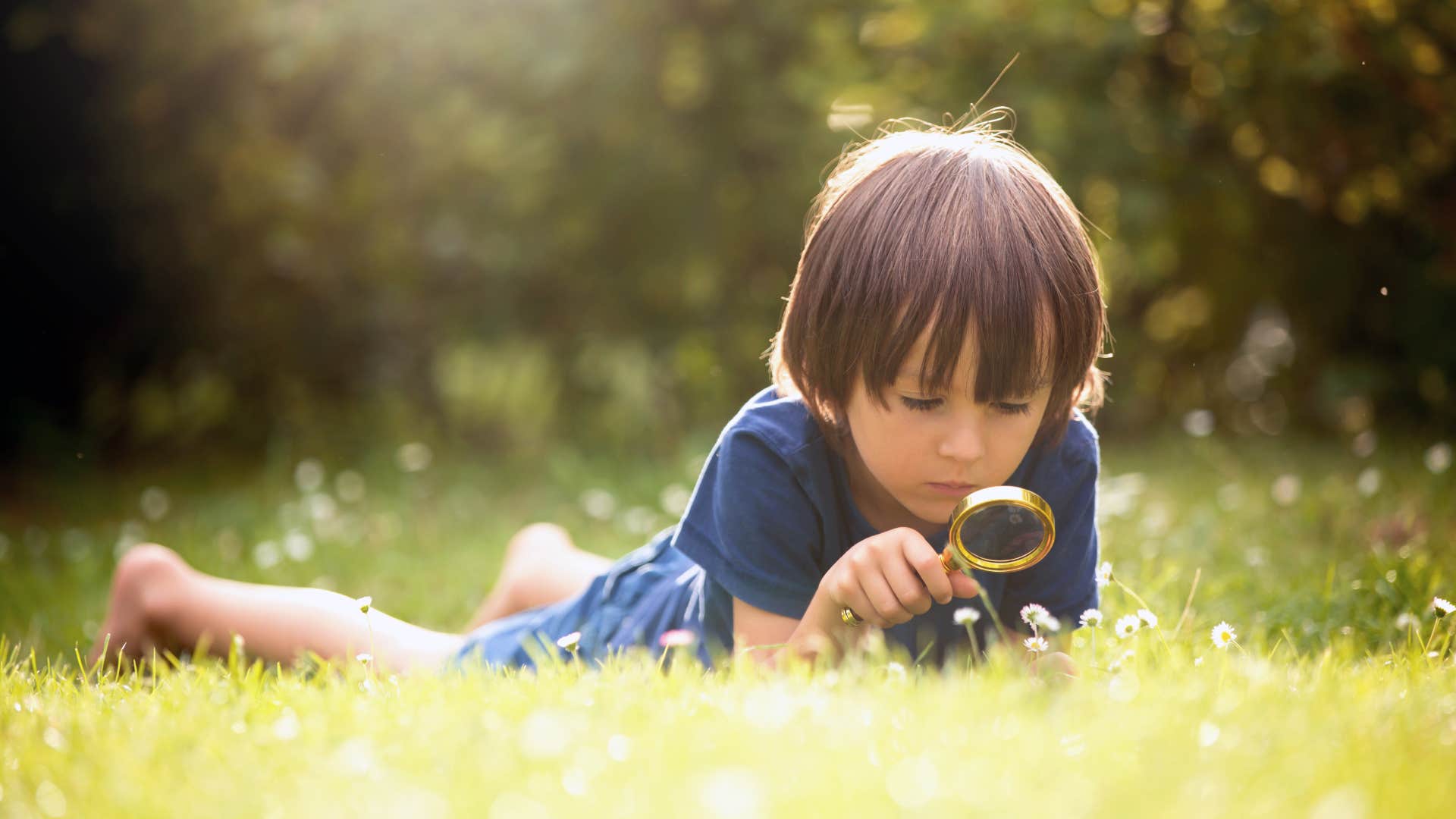 curious little boy looking at grass outside