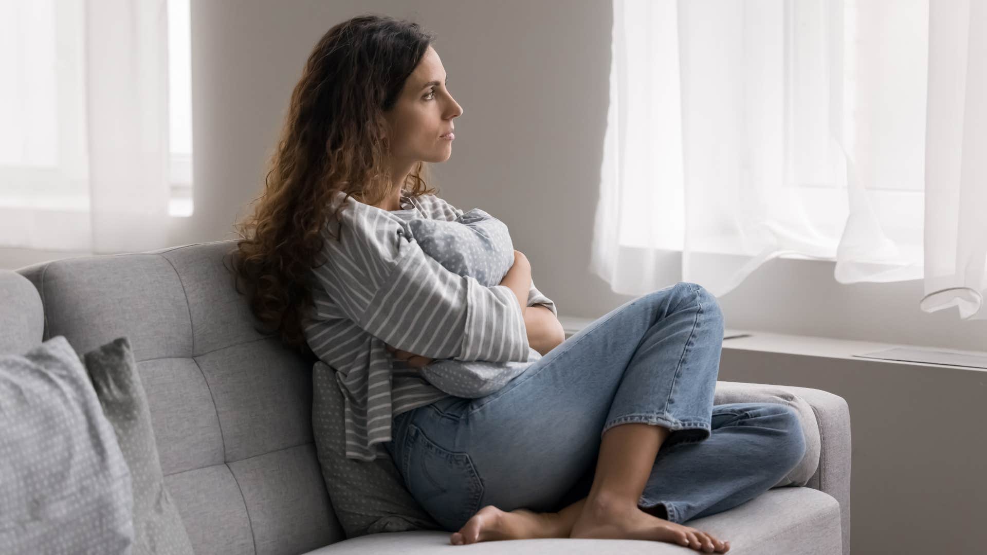 reclusive woman sitting on couch at home alone