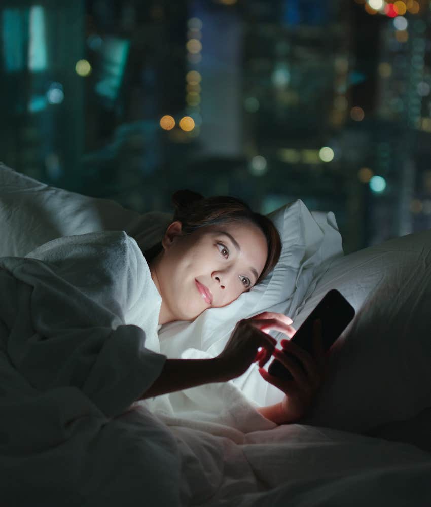 woman staying up at night scrolling on phone