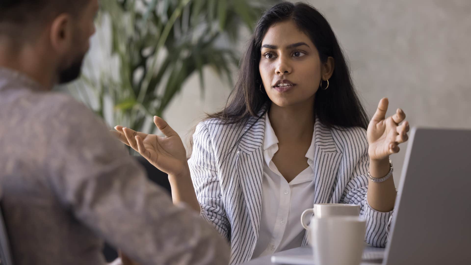 Woman saying "let's focus on solutions, not insults" to a co-worker.