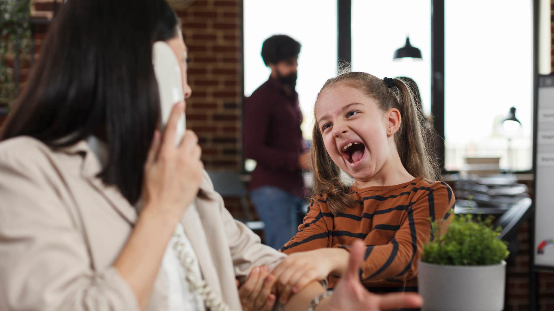 woman annoyed by child needing her attention