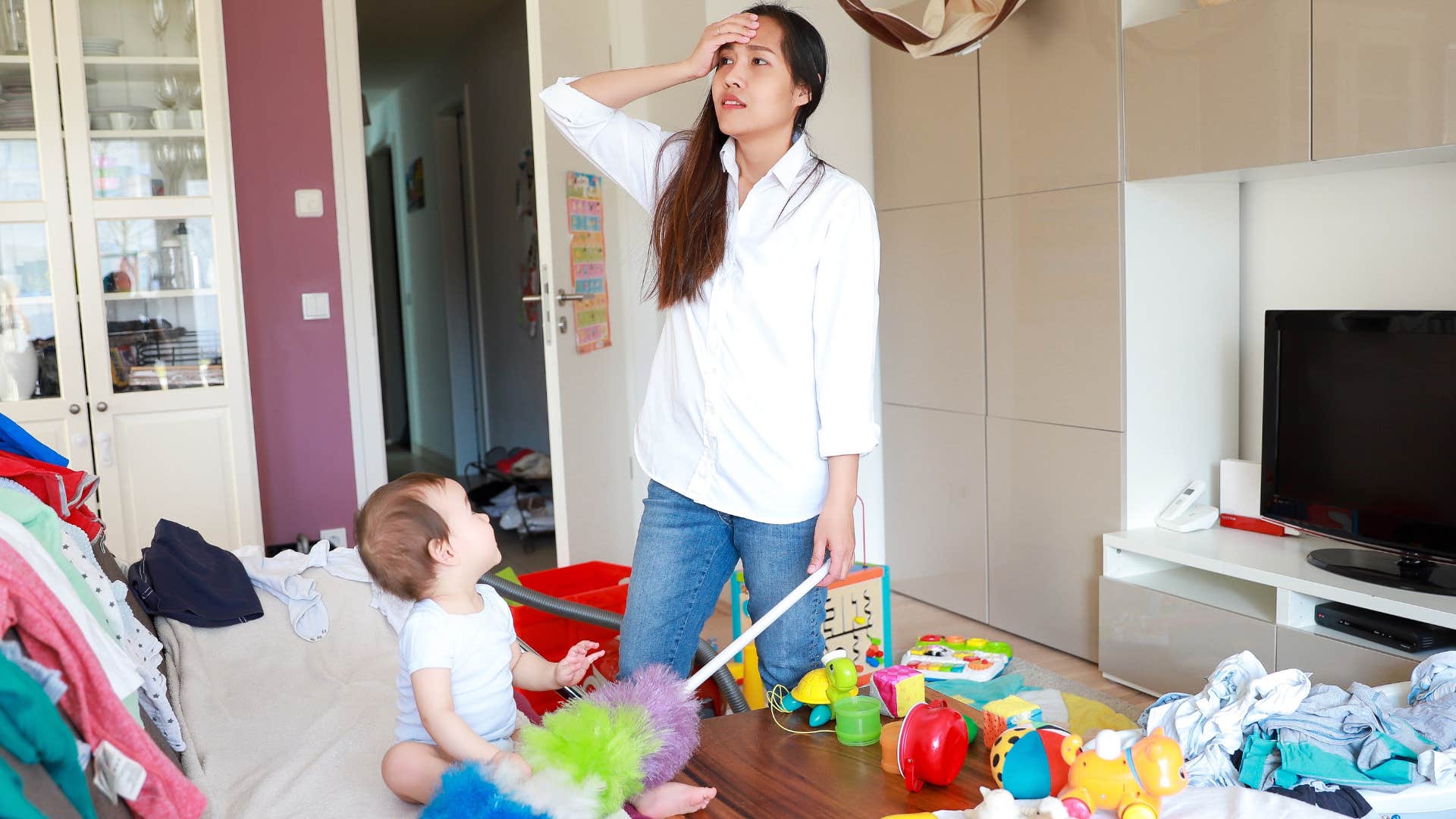 mom stressed out by messy living room full of kids toys