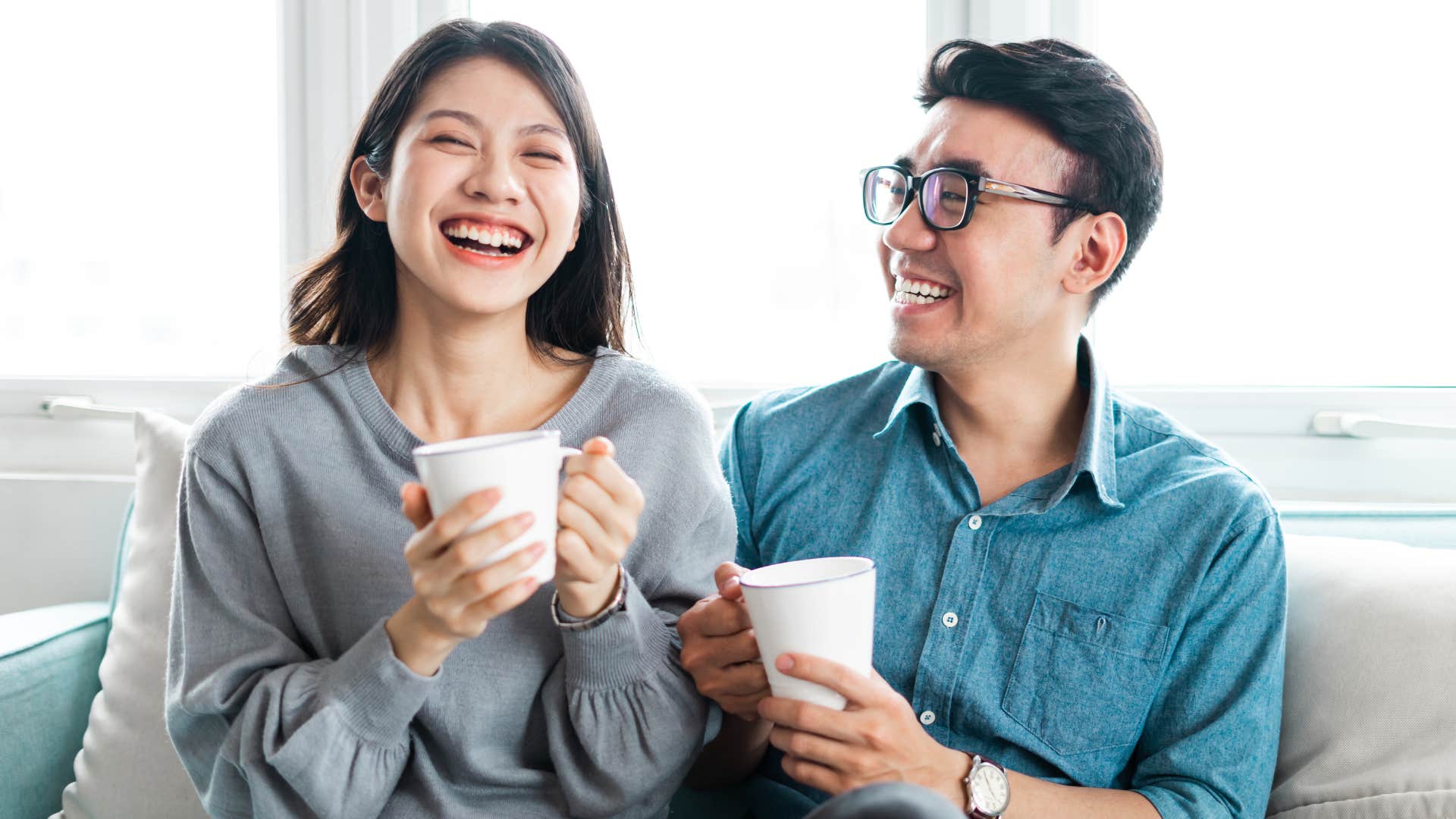 woman with mug is a natural charmer as her partner looks at her and smiles