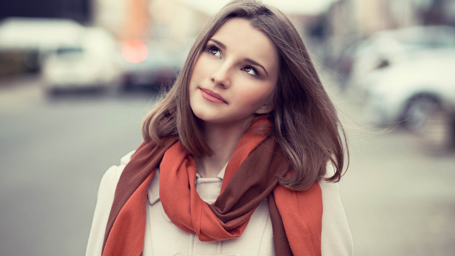 woman in red scarf daydreaming as she's someone who's wonder filled