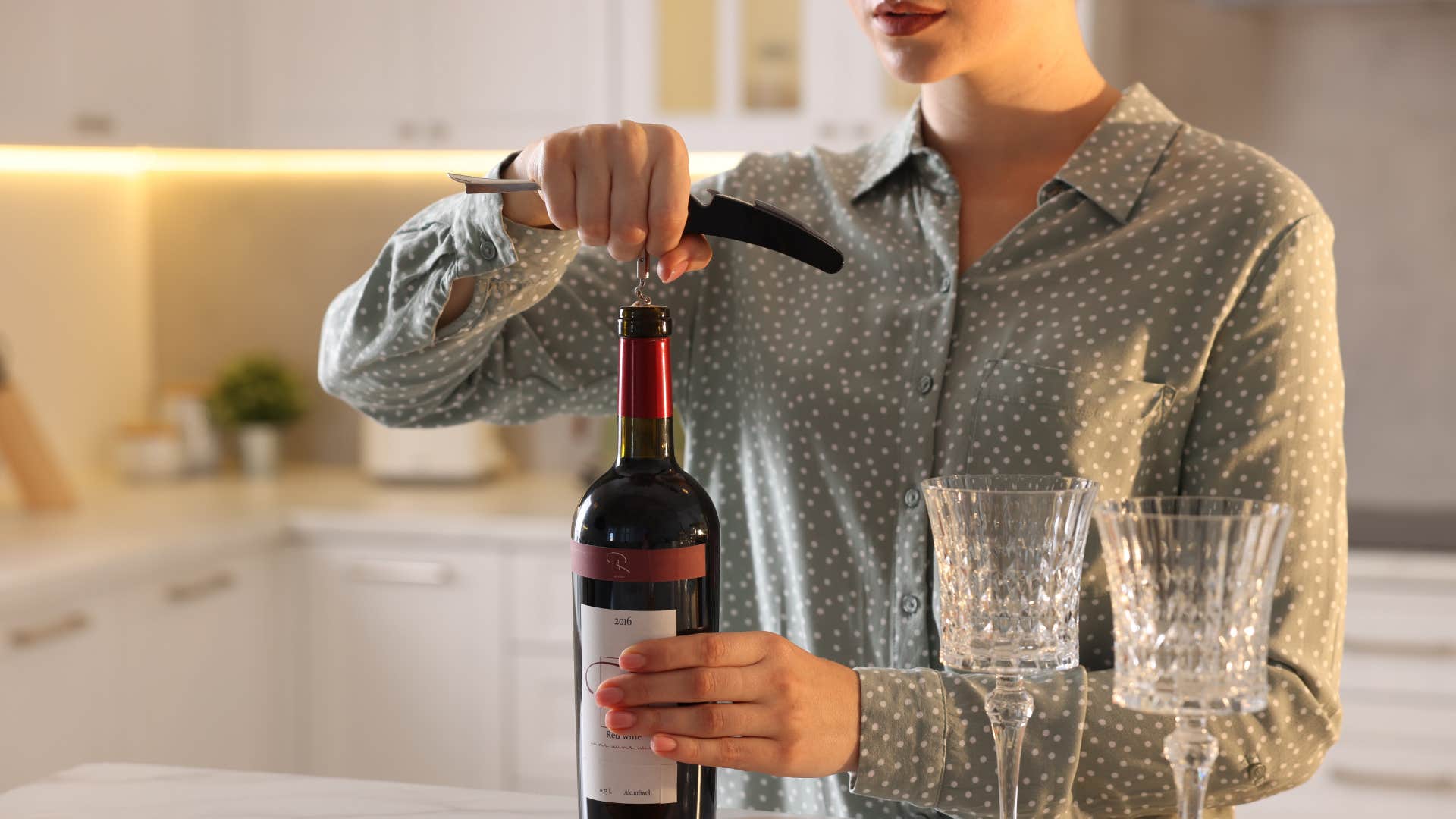 woman filling glasses of wine opening bottle