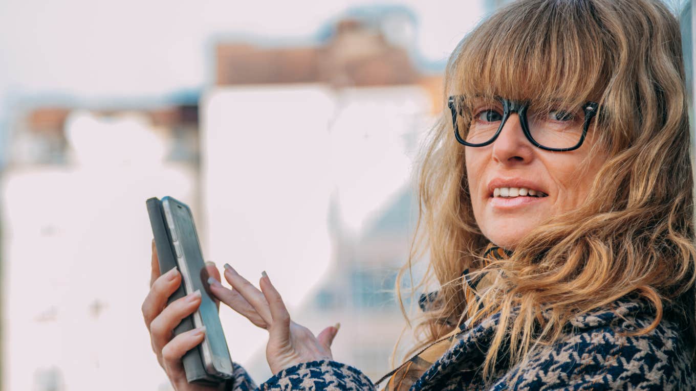 older woman looking through texts on her phone