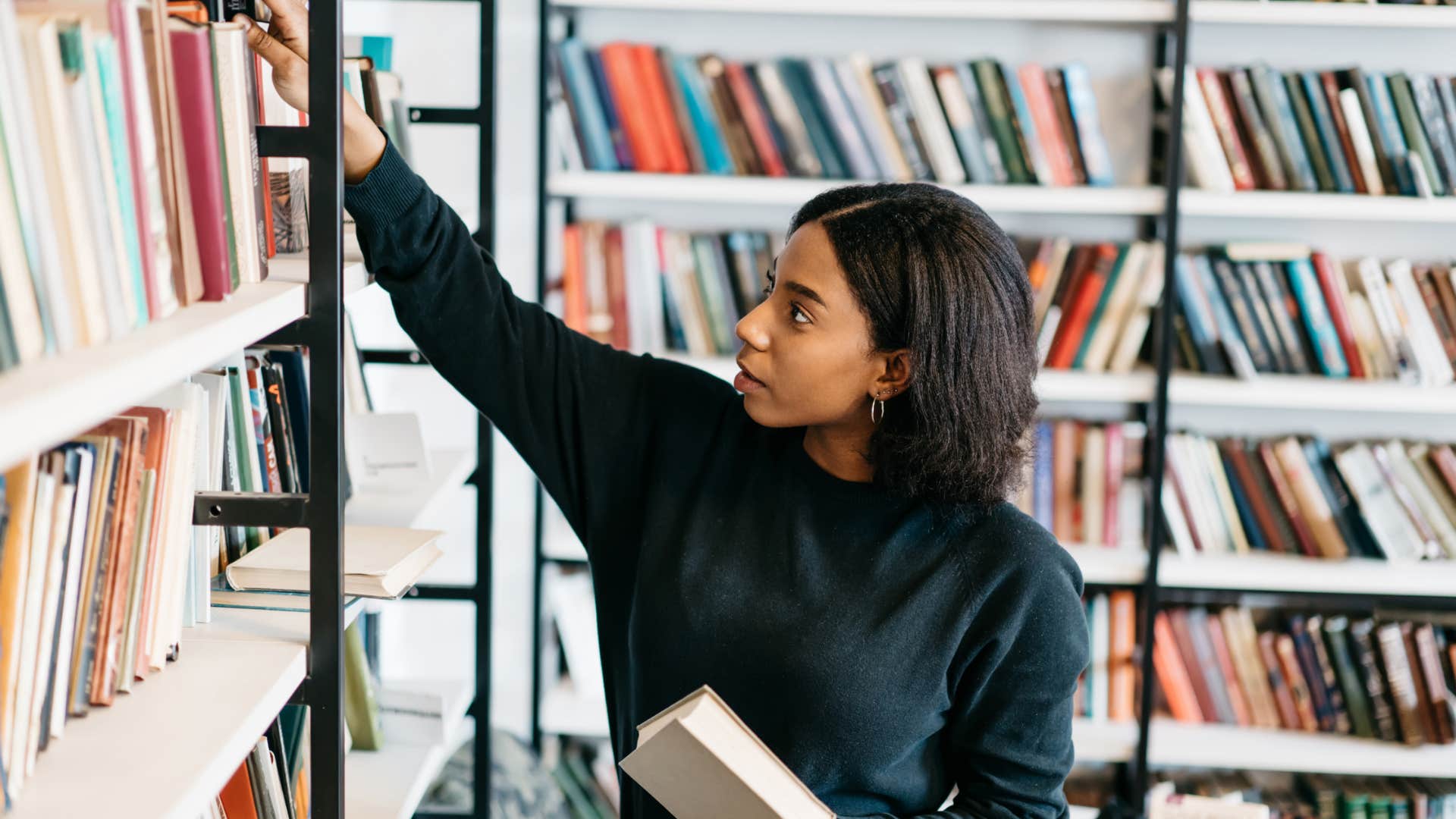 librarian returning books to the shelf