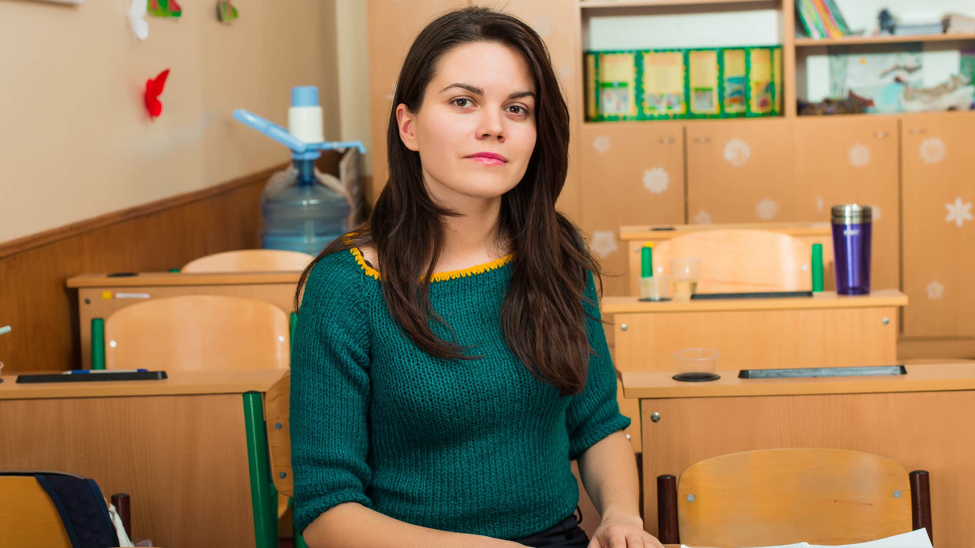 teacher sitting in empty classroom
