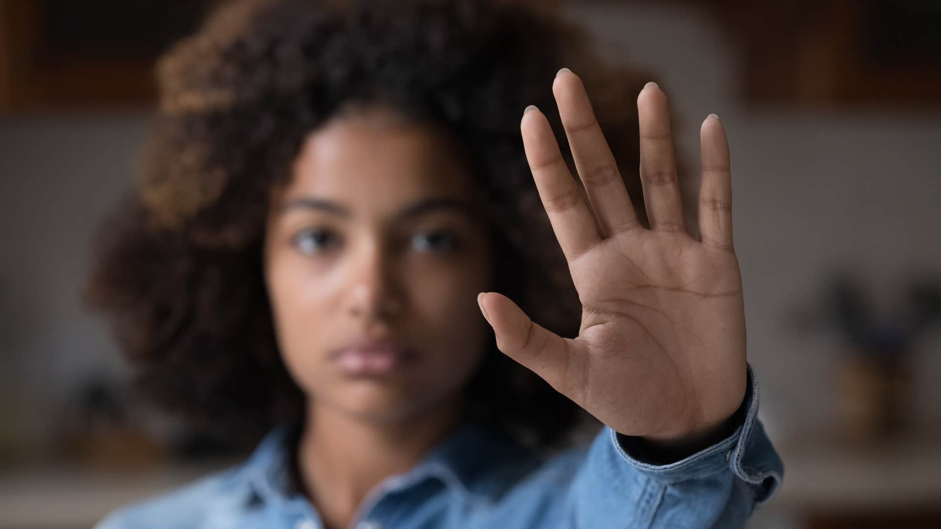 Uninterested woman puts up hand as brush off