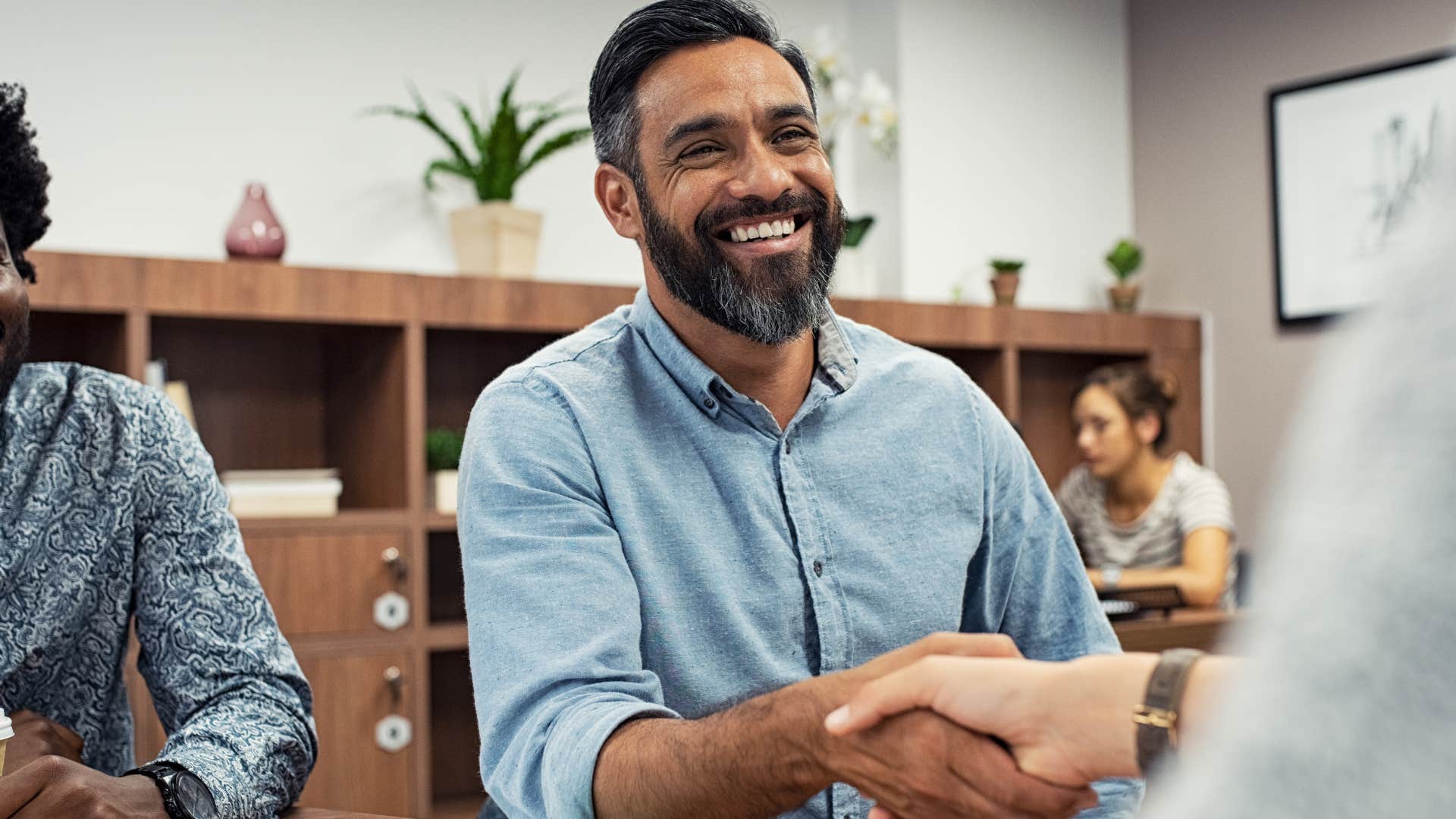 Man who's charming to everyone talking to people at work.