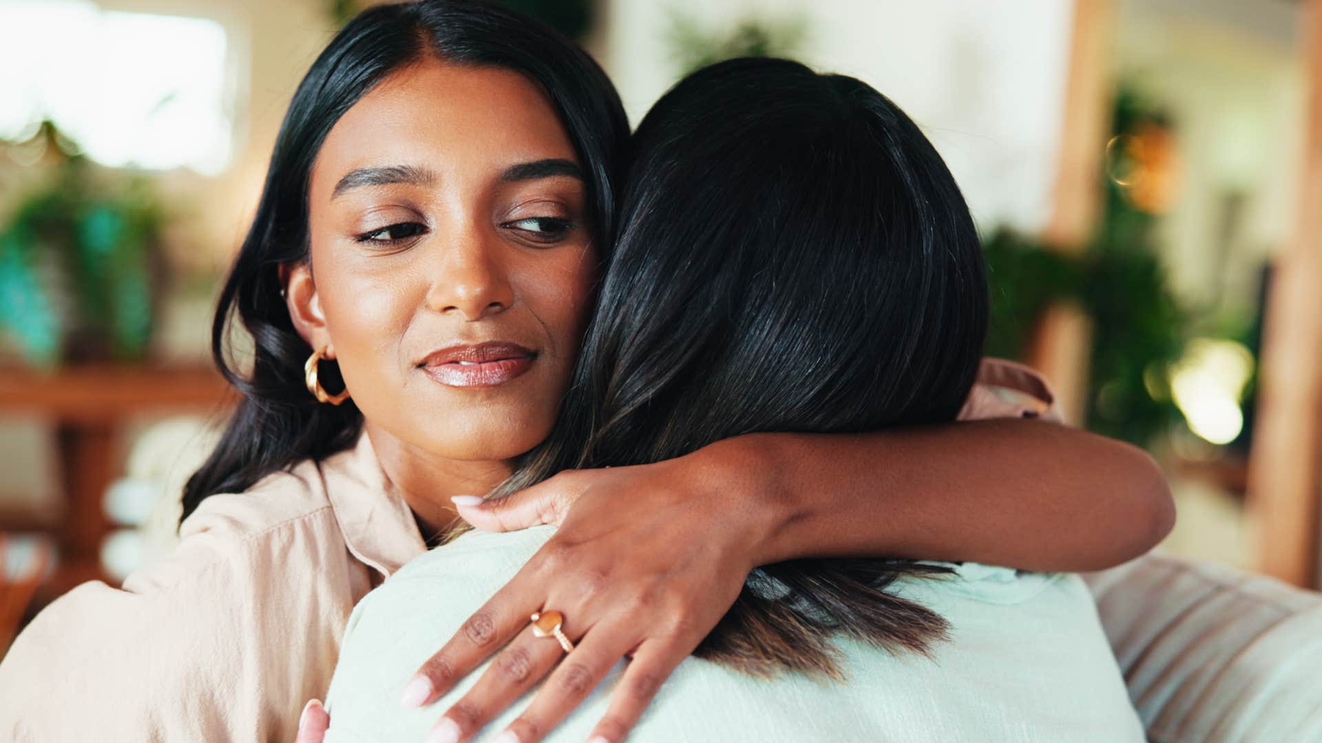 woman hugging friend while mocking her dreams