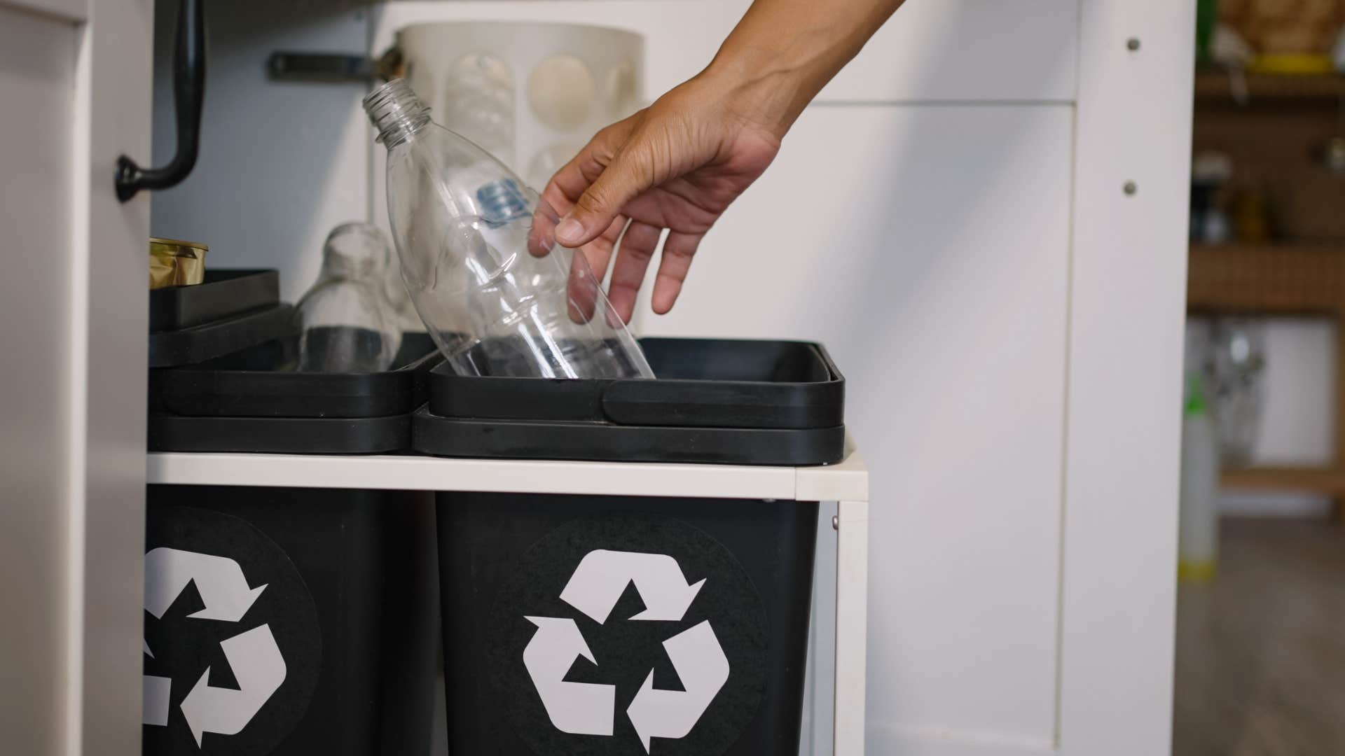 middle class person using trashcan hidden in their cabinet