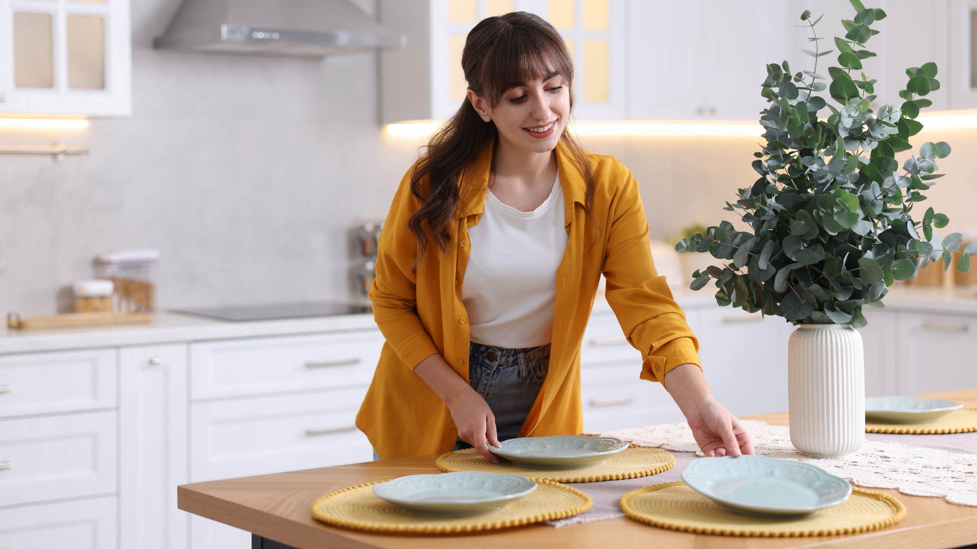 middle class woman setting matching dishes on the table