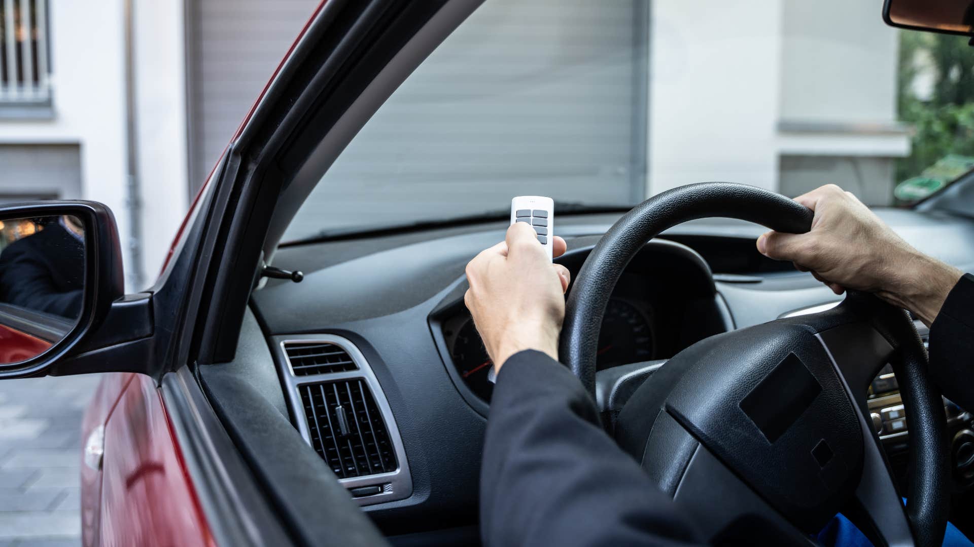 middle class person in their car using an automatic garage door opener