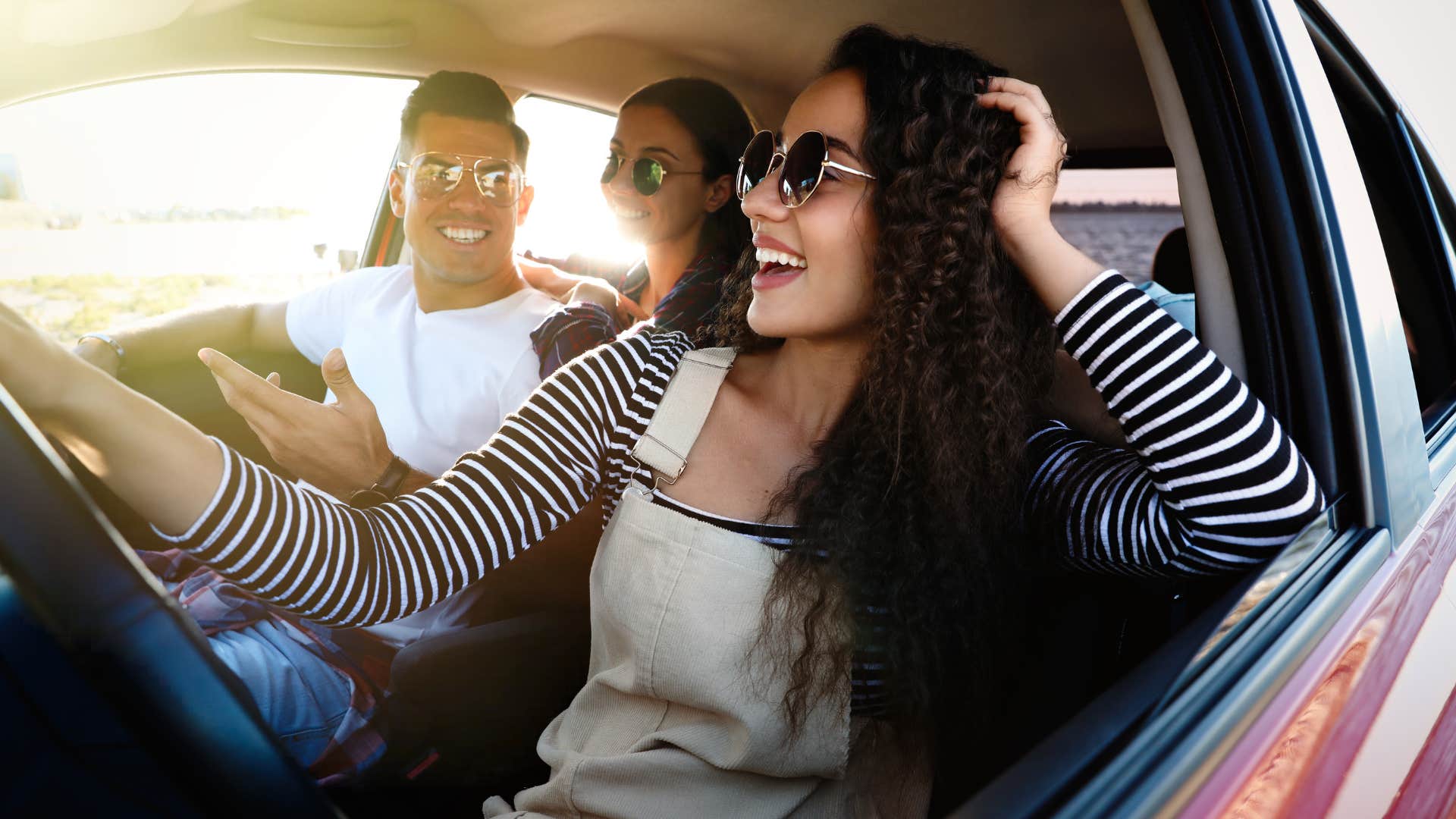 carefree woman riding in her car with friends