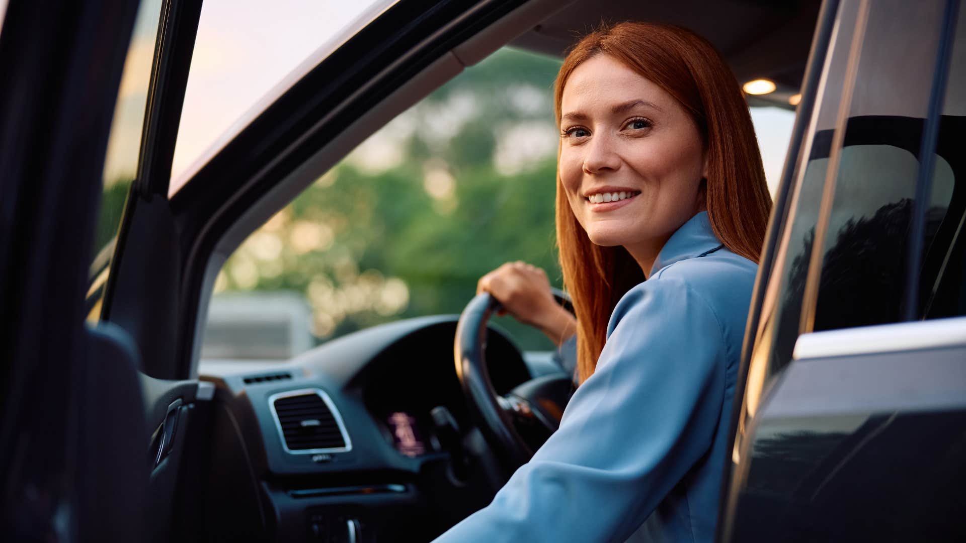 woman smiling sitting in car telling friend it's a little messy