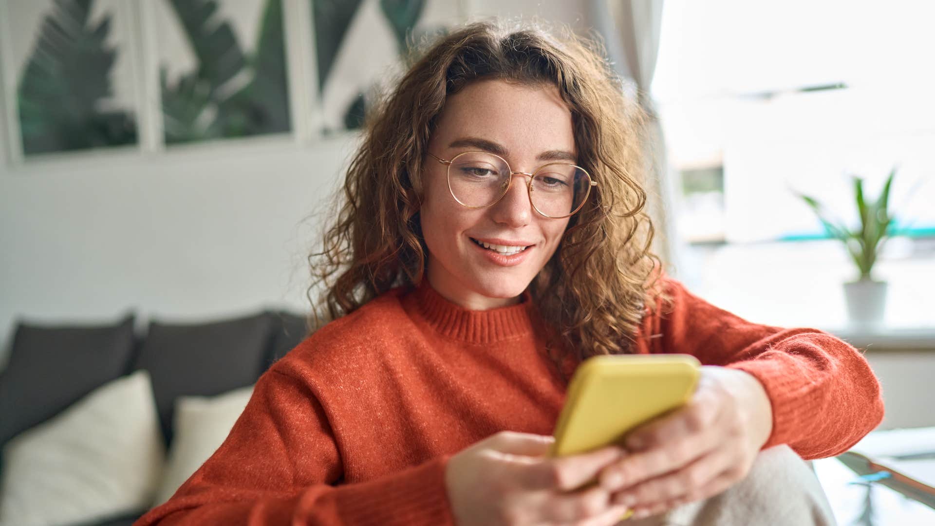 woman in red on phone doesn't double check her sources as she smiles