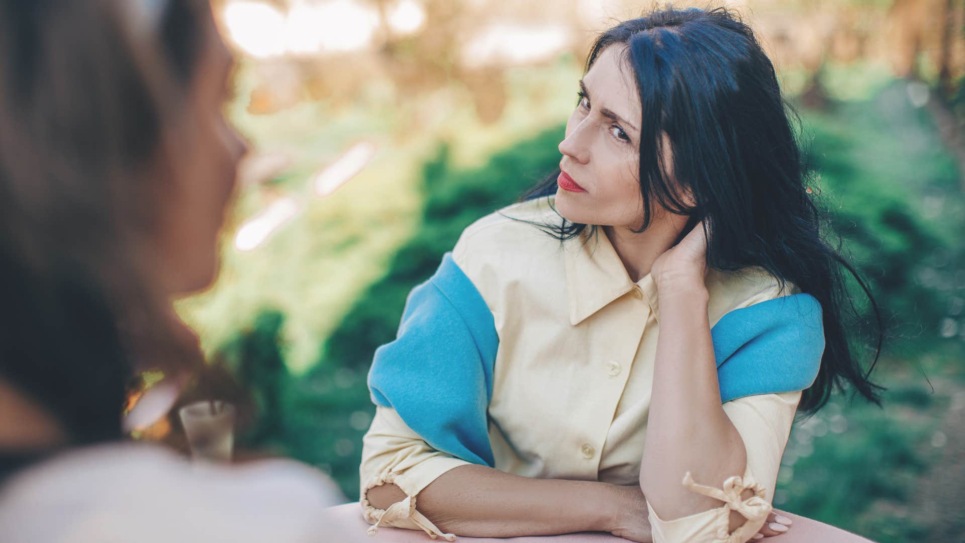 woman scratching her head judging friend