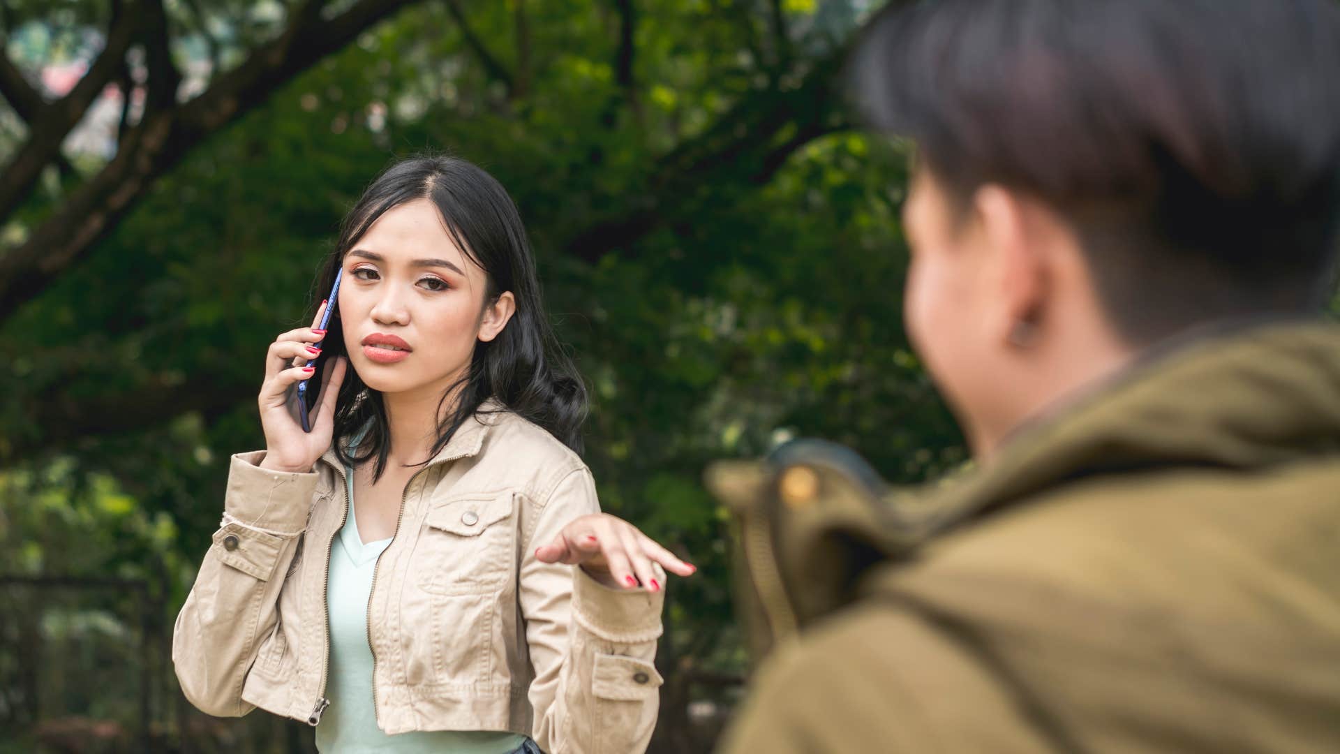 woman shooing away man telling him whatever