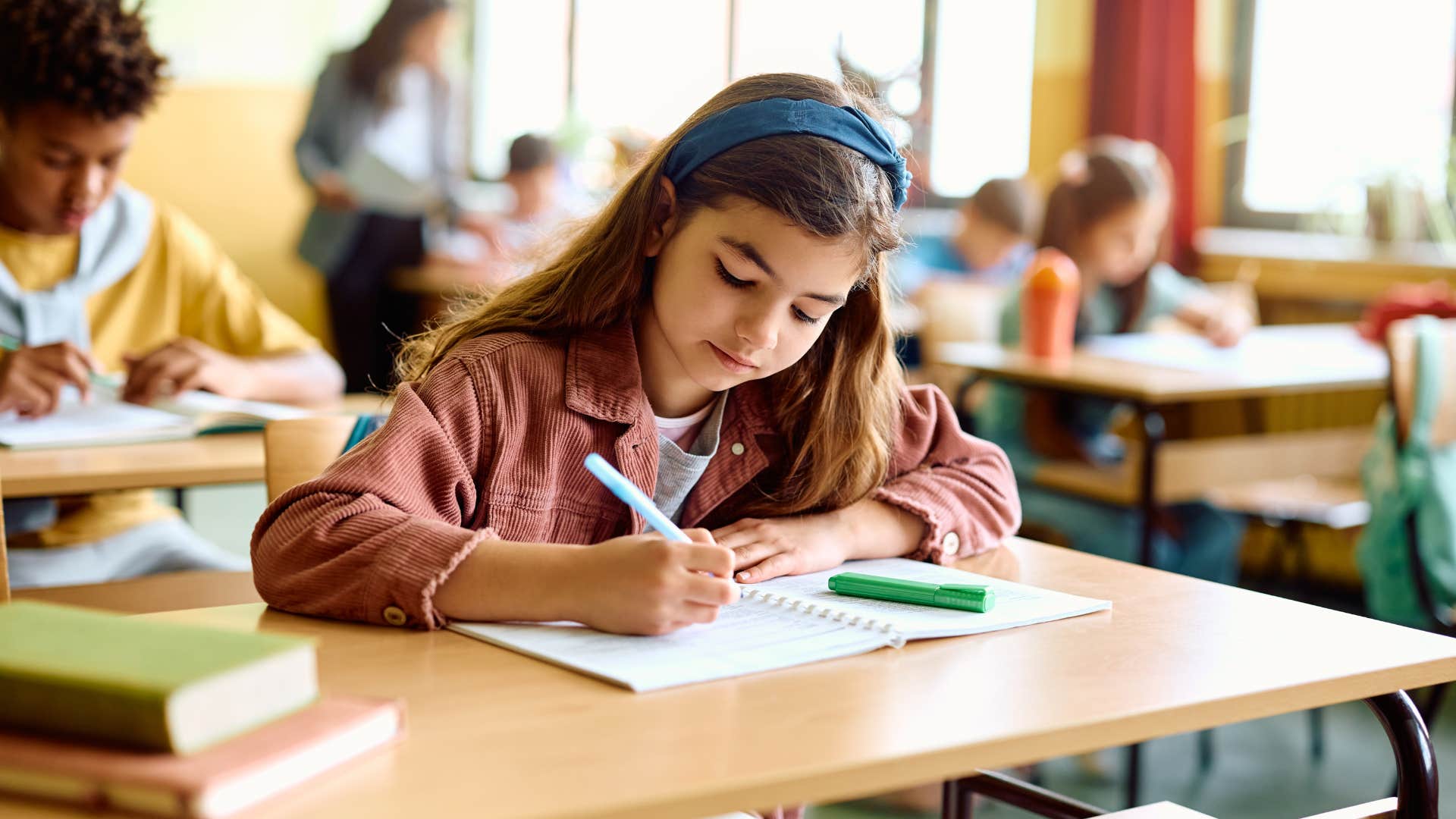child doing a writing assignment in class