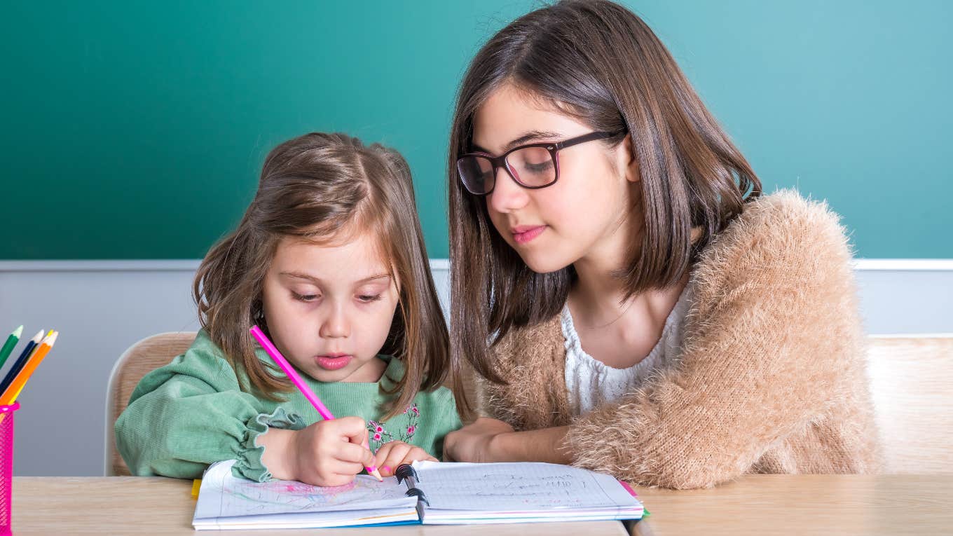 teen girl mentoring a toddler