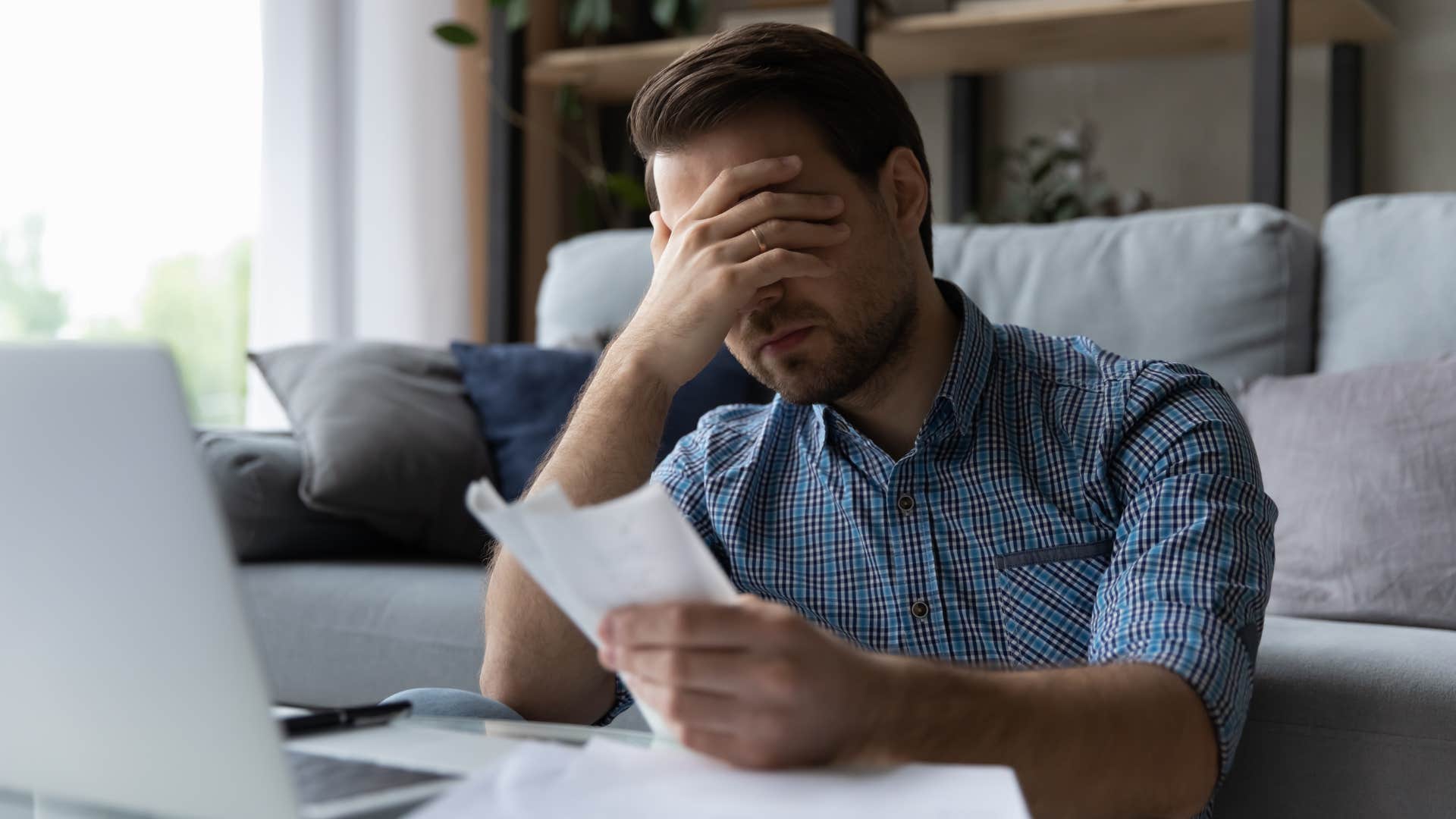 man looking at his debt stressed out