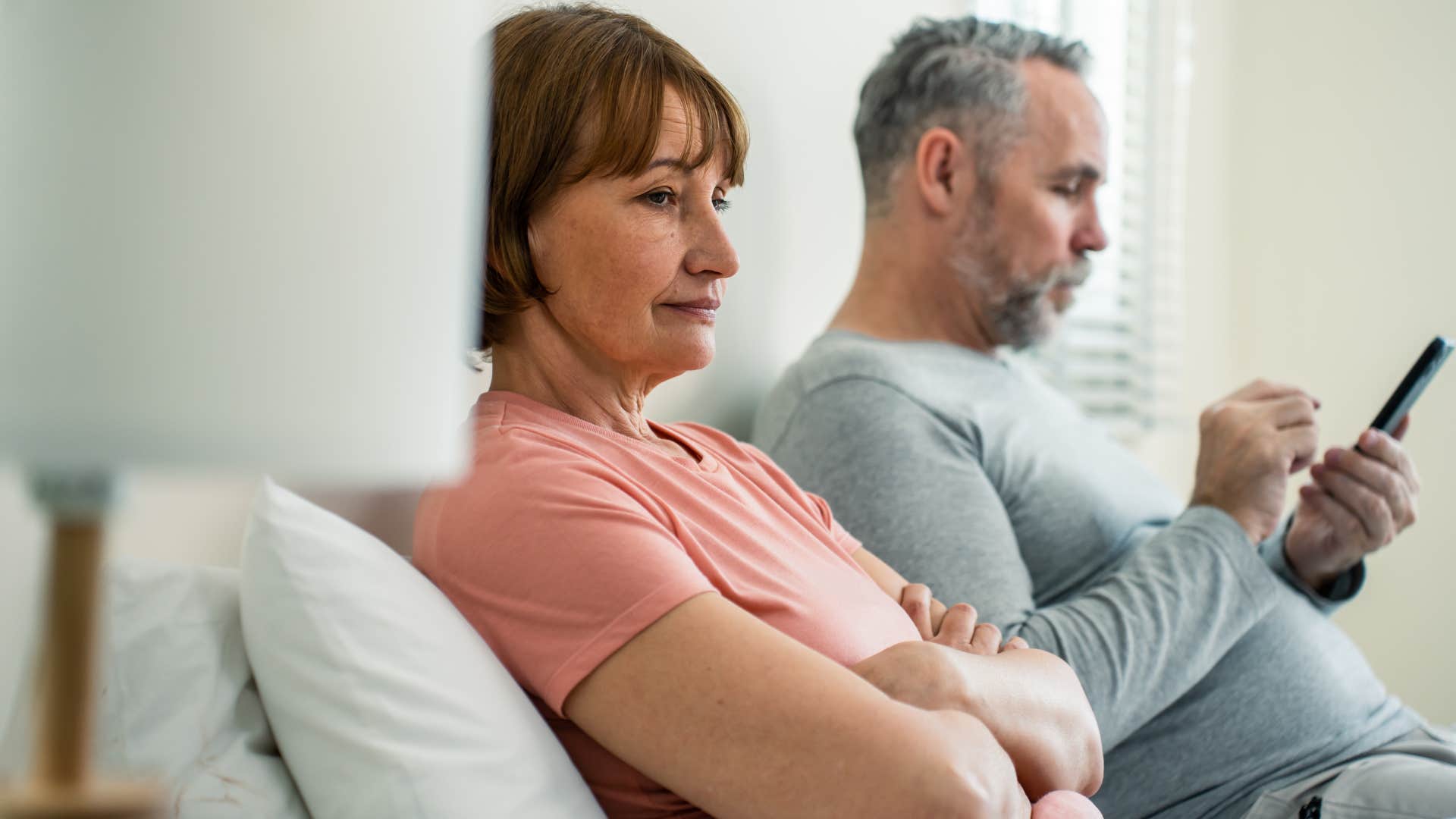 Woman sitting by her husband and forgiving him silently.