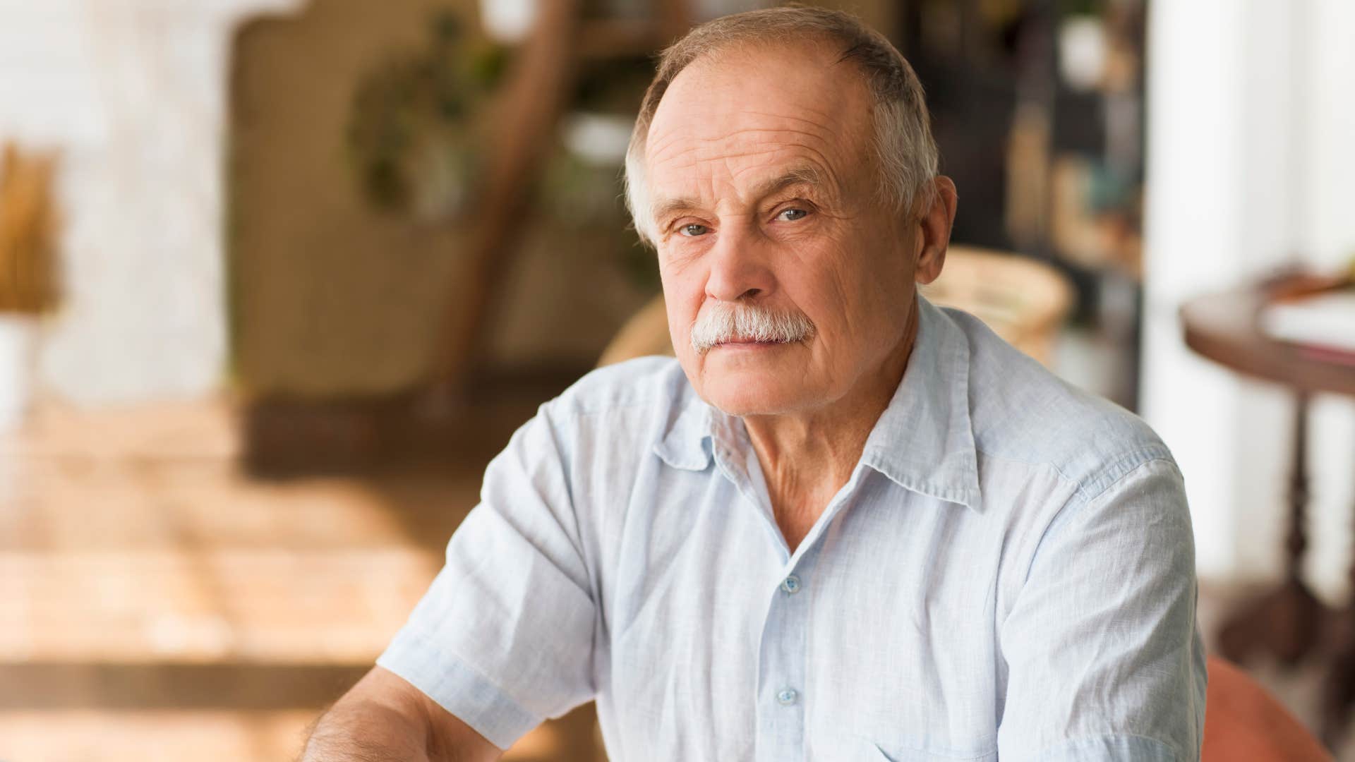 older man sitting at home unable to trust others