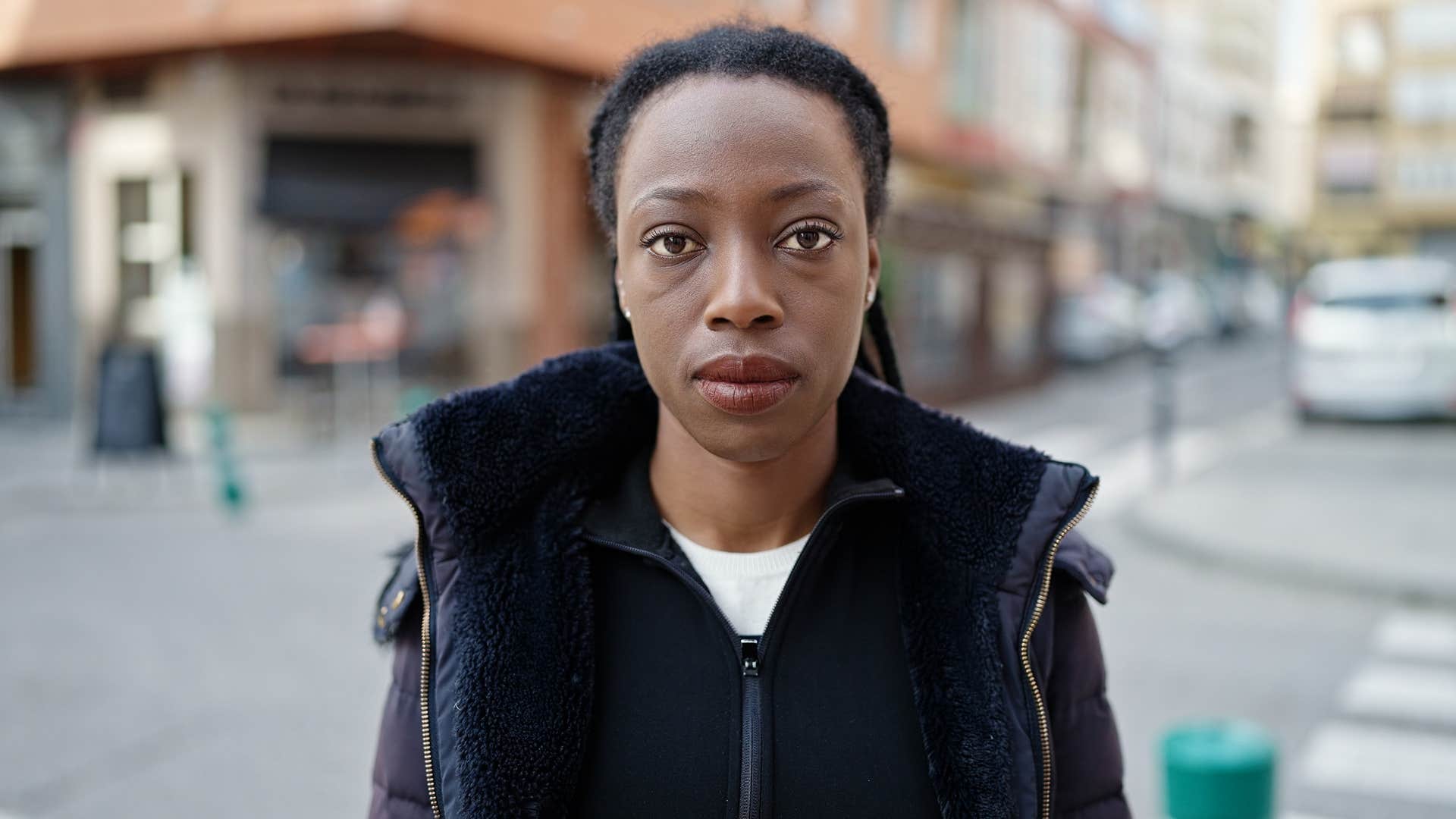 serious woman with people-pleasing tendencies standing in street